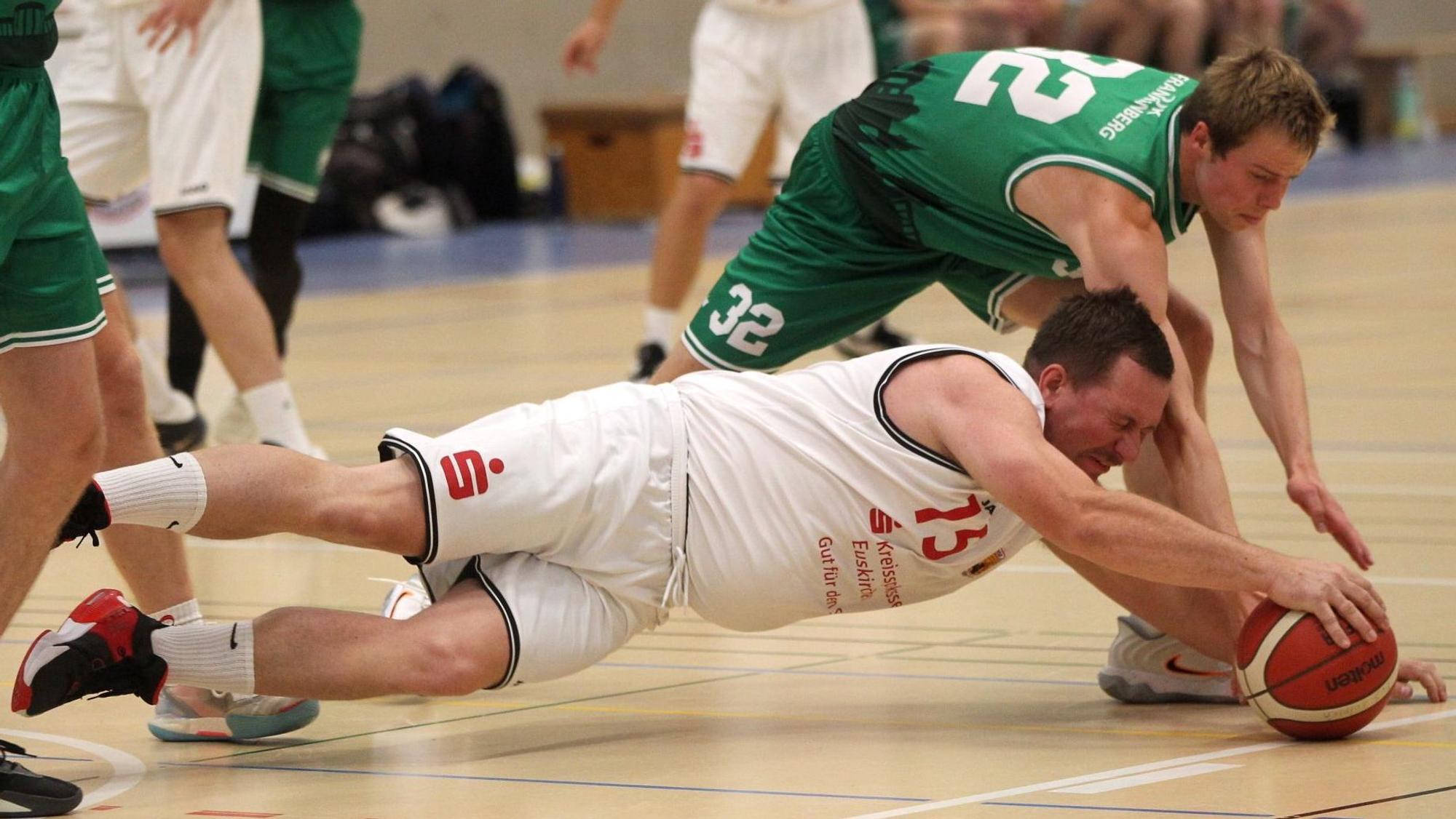Ein Spieler liegt am Boden, lässt den Ball aber nicht los.