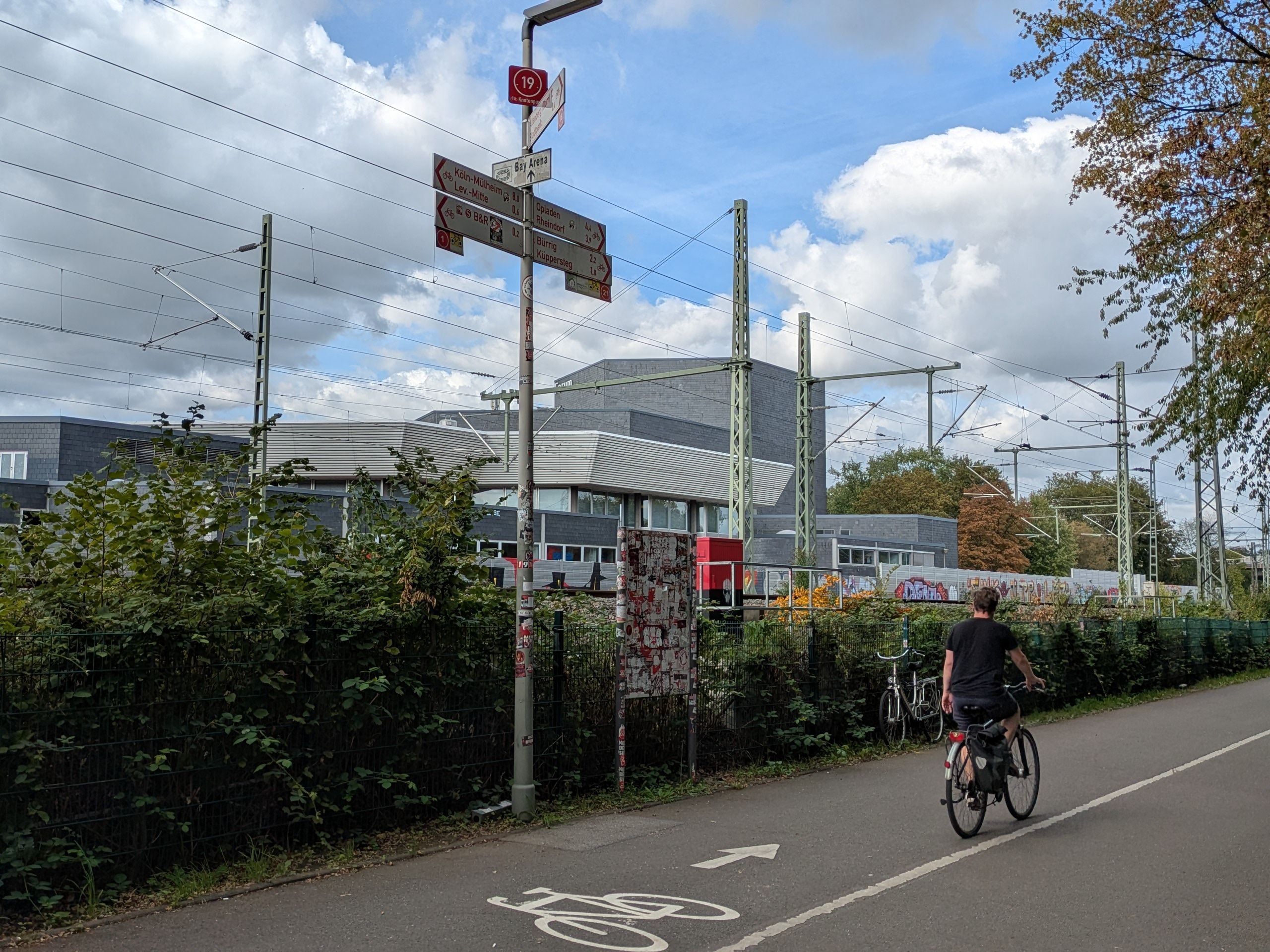 Ein Radfahrer auf einem Radweg neben einer Bahnlinie in Wiesdorf