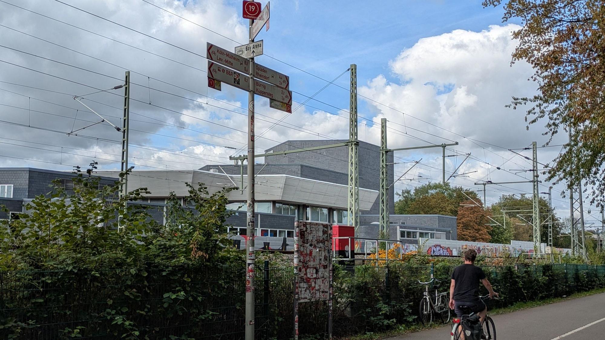 Ein Radfahrer auf einem Radweg neben einer Bahnlinie in Wiesdorf