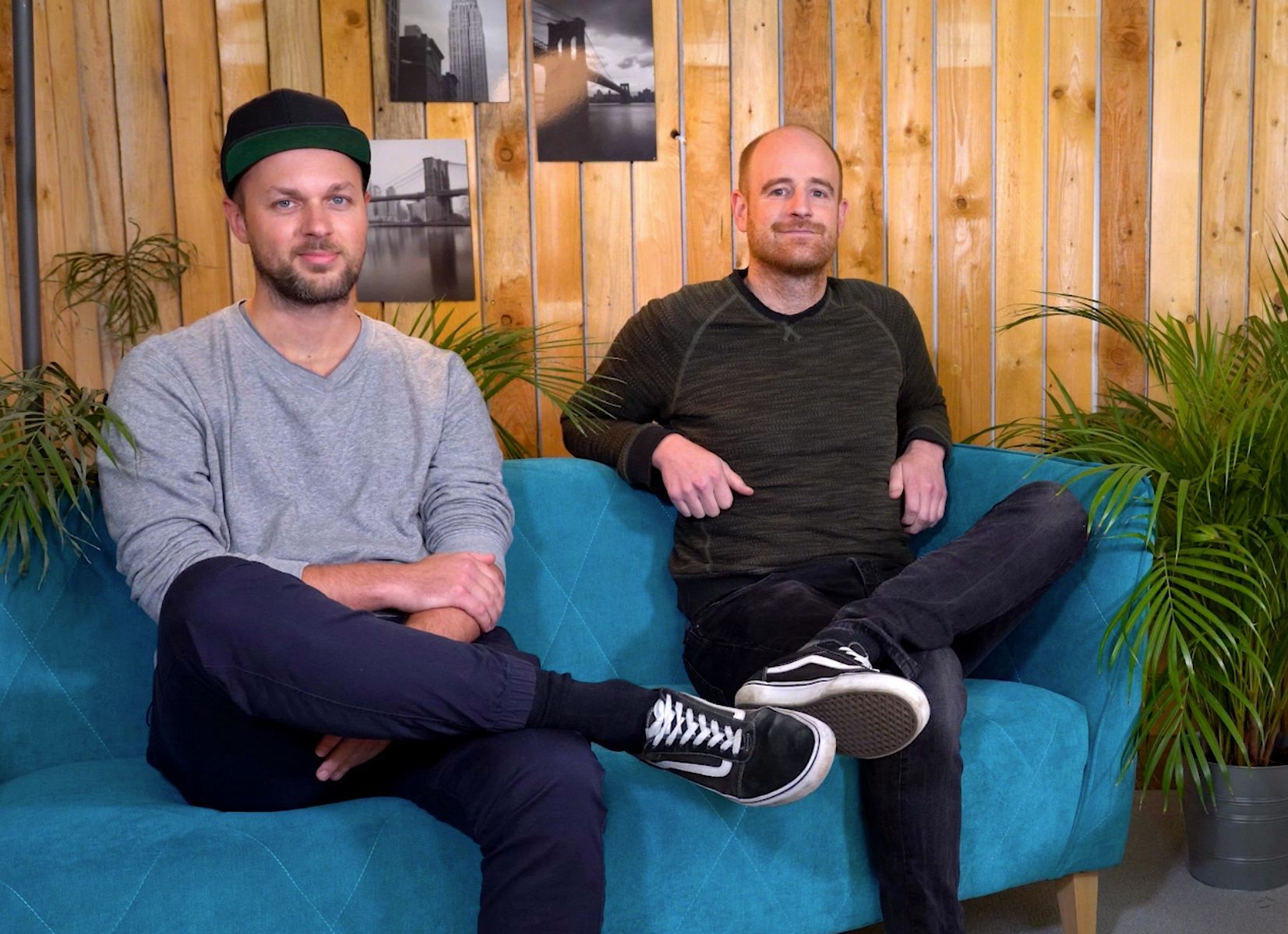 Das Foto zeigt zwei Männer auf einer Couch.