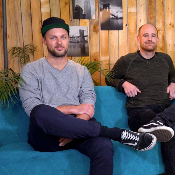 Das Foto zeigt zwei Männer auf einer Couch.