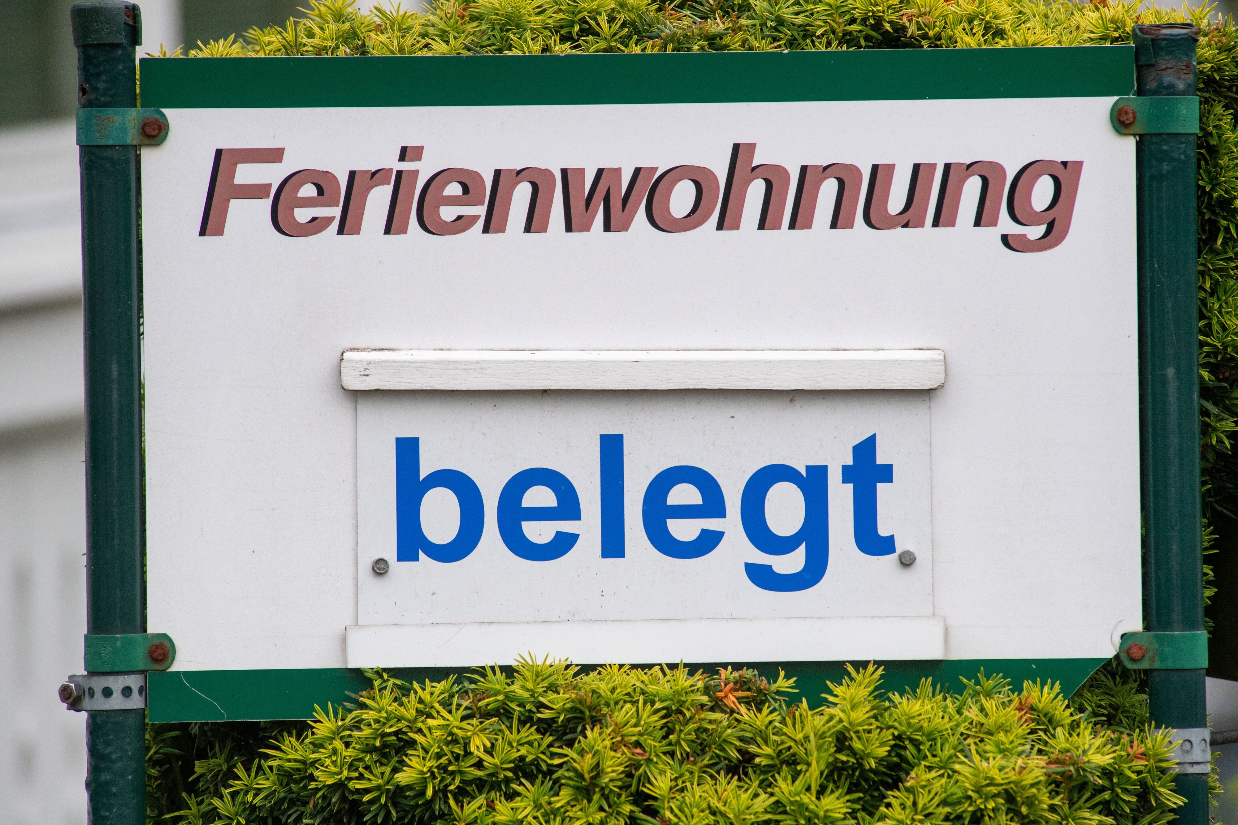 Das Symbolbild zeigt ein Schild mit dem Schriftzug "Ferienwohnung belegt".