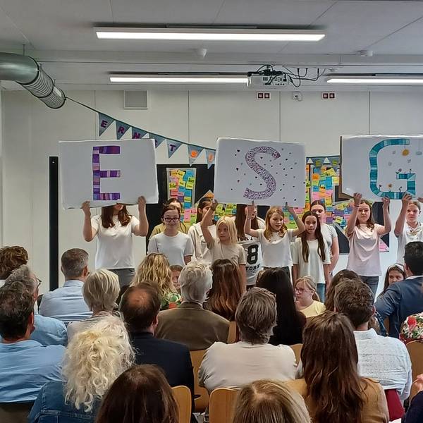Schüler stehen vor ihrem Publikum in einer Klasse.
