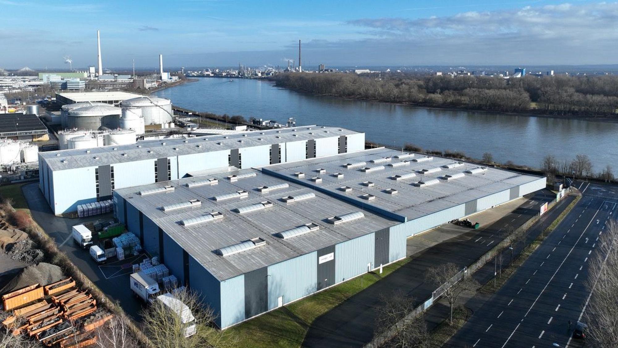 Blick auf die Logistikhallen am Niehler Rheinufer: Die höhere der beiden Hallen, im Hintergrund, beziehen die KVB als Lagerstätte.