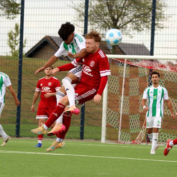 Bei einem Kopfballduell prallen zwei Fußballer zusammen.