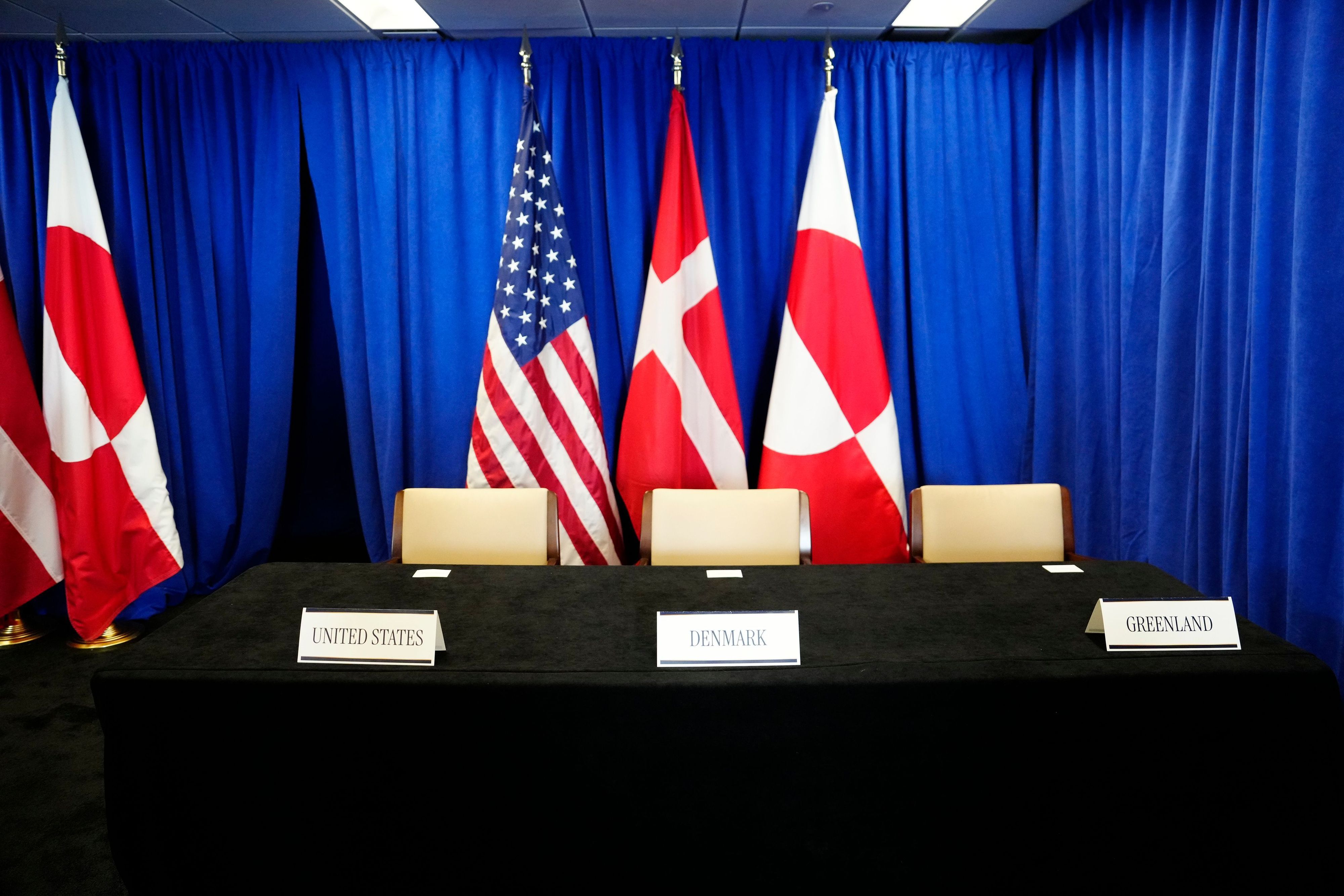 Die Flaggen der USA (M, l-r), Dänemarks und Grönlands stehen in einem Raum anlässlich der Unterzeichnungszeremonie eines Sicherheitsabkommens zwischen den USA, Dänemark und Grönland im Hauptquartier der Vereinten Nationen.