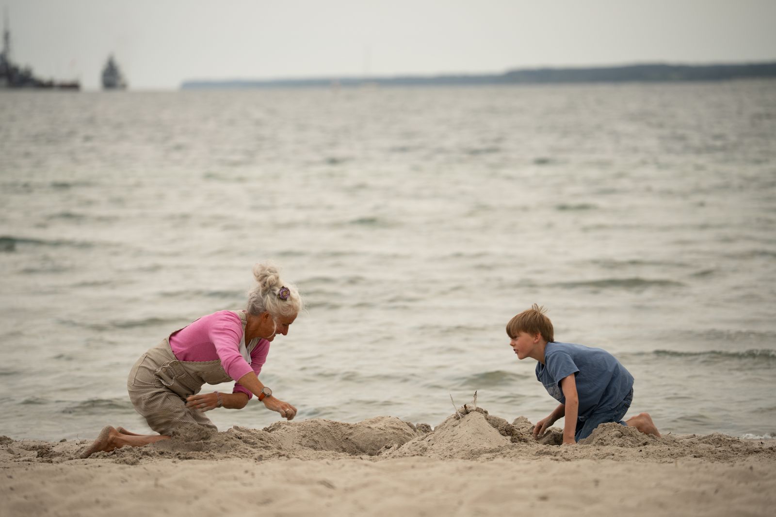 Britta spielt mit ihrem Enkel Emil am Strand. Unter der Vorstellung „meine Freunde, Kinder, Enkel zu verlieren“, leidet sie besonders. (Bild: ZDF/Greb + Neckermann Filmproduction)