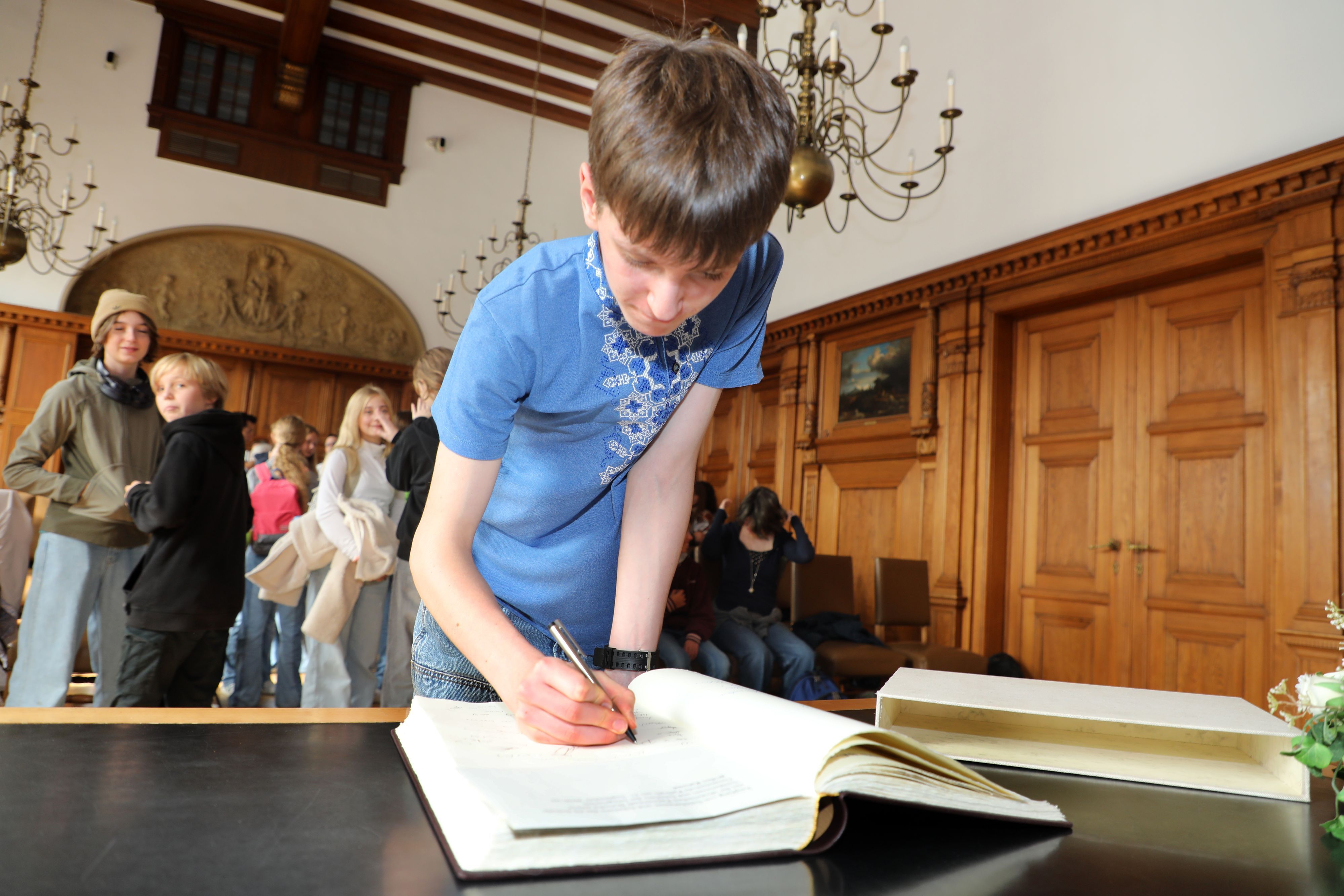 Ins Goldene Buch der Stadt Bergisch Gladbach tragen sich die Jugendlichen aus Butscha ein.