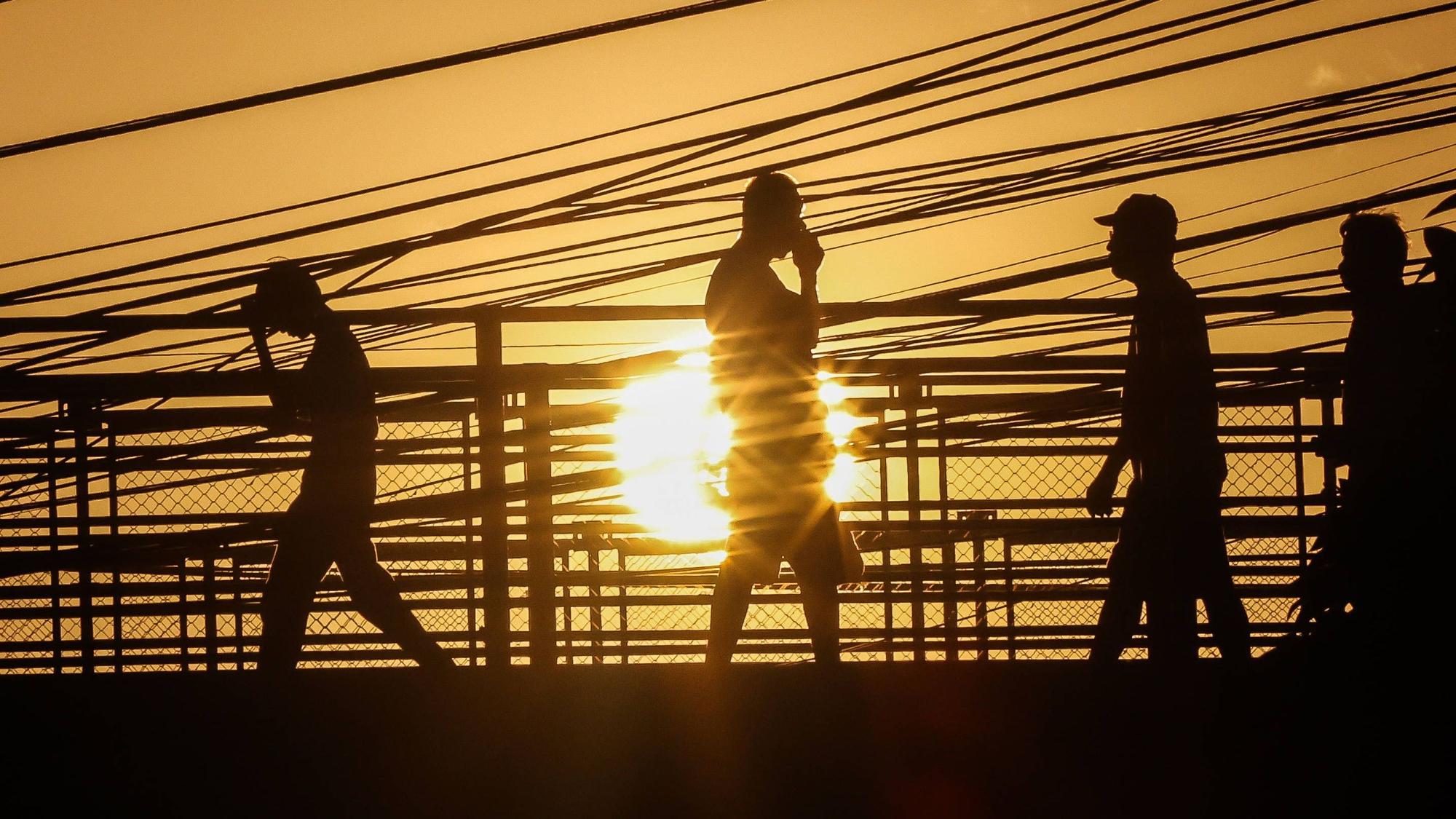 Menschen gehen unter der sengenden Sonne in Quezon City auf den Philippinen spazieren. (Archivbild)
