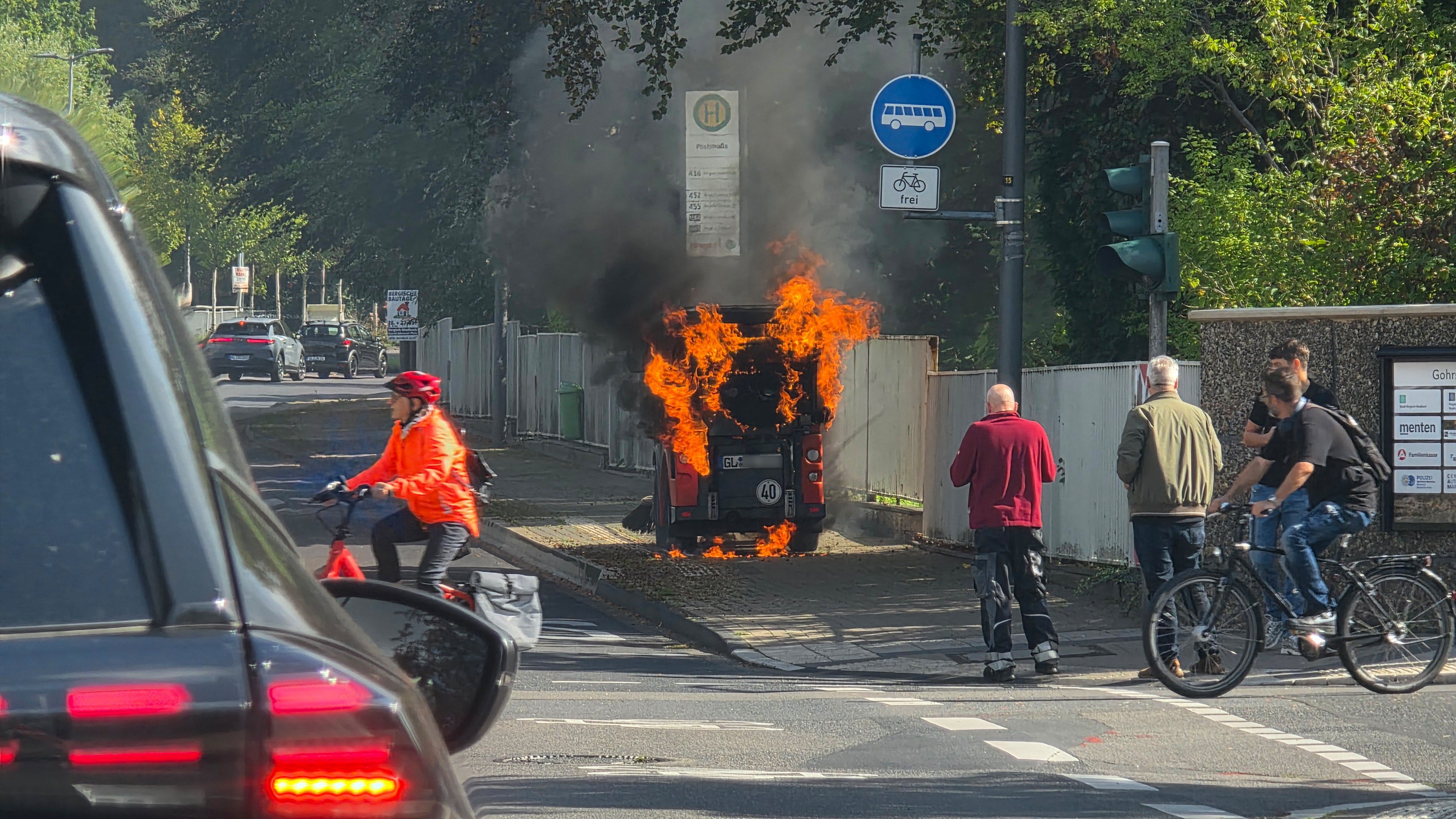 Auf dem Gehweg neben der Straße An der Gohrsmühle brennt eine Kehrmaschine.