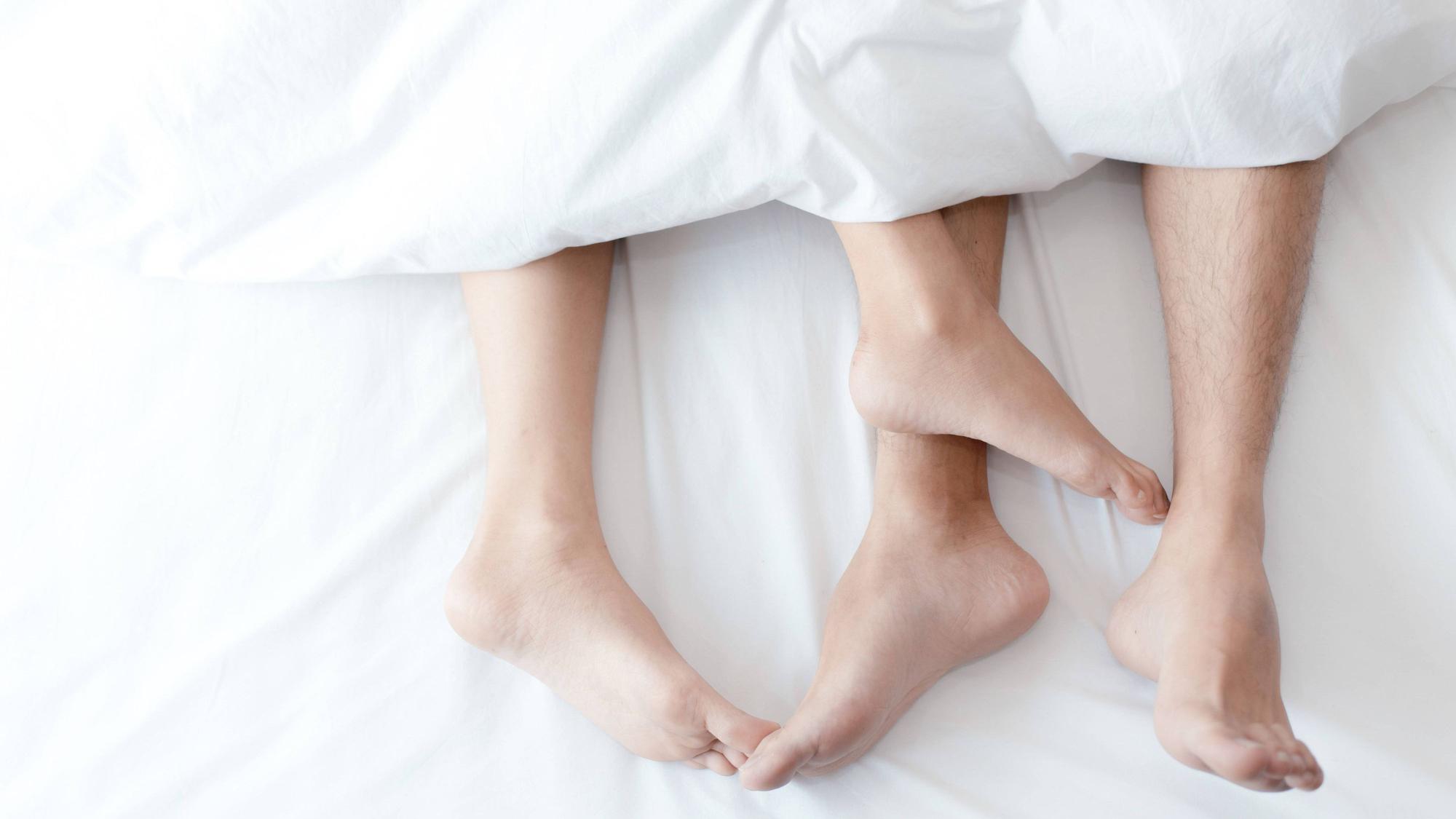 Nahaufnahme Füße des Paares auf dem Bett.