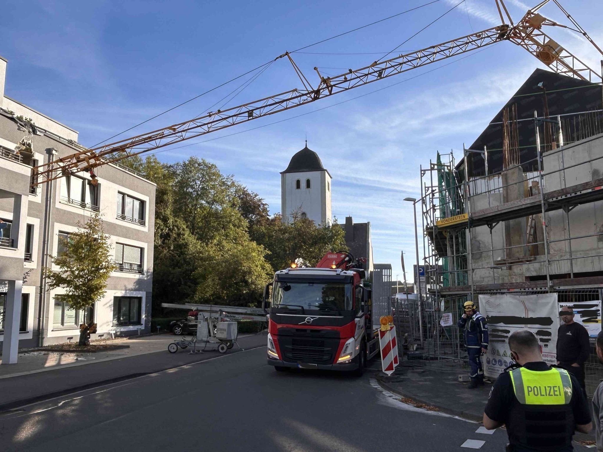 Kran kippt und stürzt auf Wohnhaus
