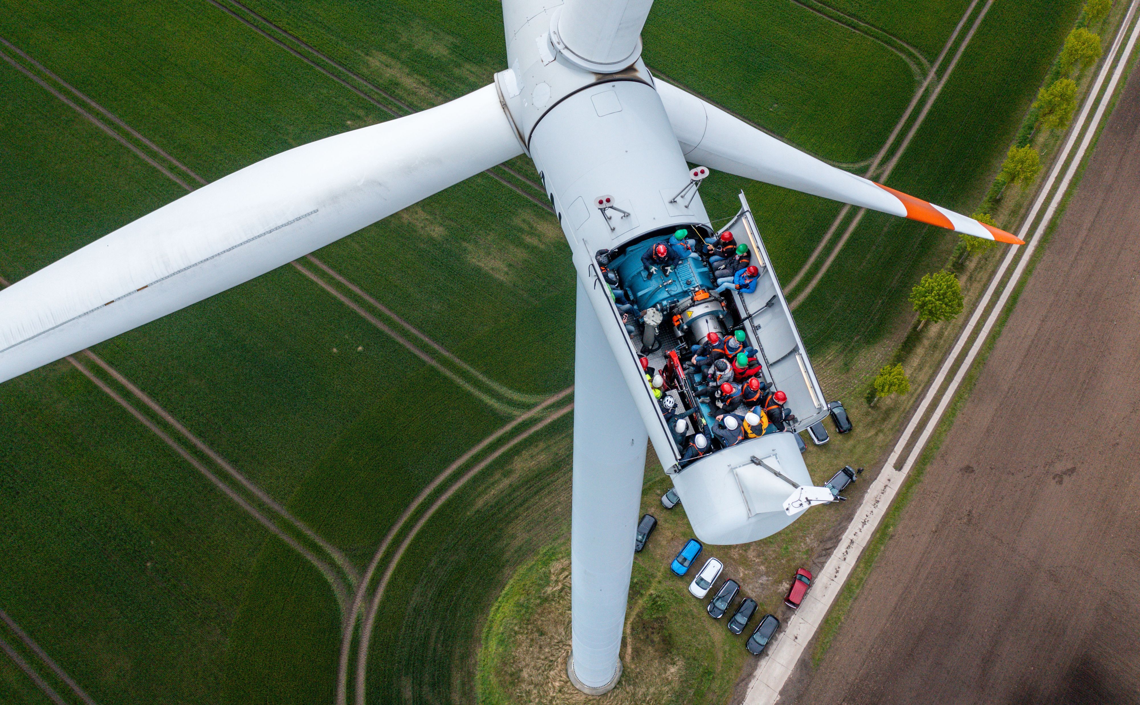 Bürgermeister, Lokalpolitiker und interessierte Bürger besichtigten die Turbinen auf einer Windkraftanlage mit geöffnetem Dach.