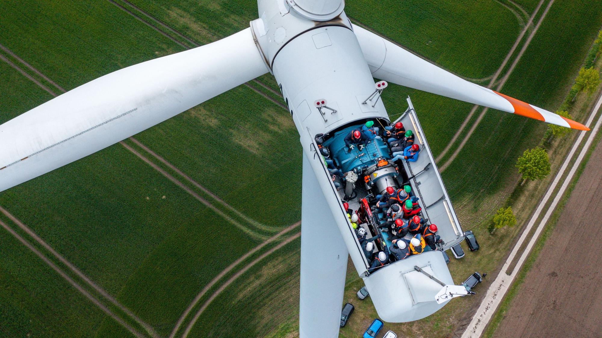 Bürgermeister, Lokalpolitiker und interessierte Bürger besichtigten die Turbinen auf einer Windkraftanlage mit geöffnetem Dach.
