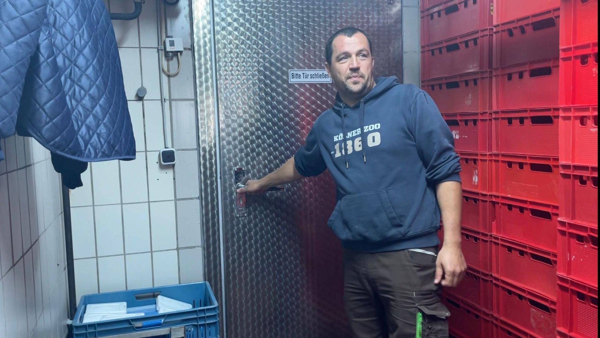 Ingo Linden öffnet die Tür zur Kältekammer im Kölner Zoo. Darin befinden sich rote Kisten voll mit Fleisch.
