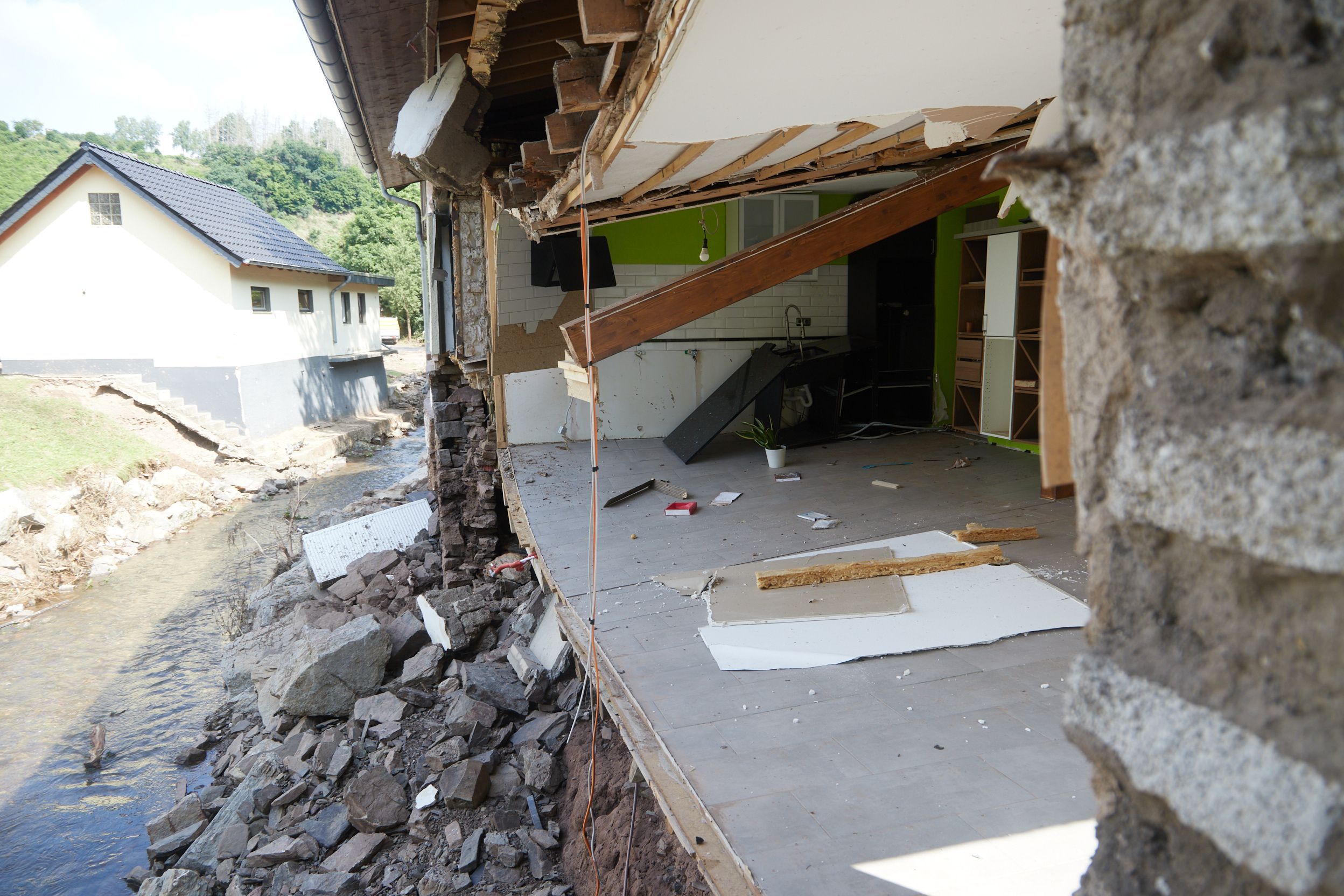 Die Fassade eines Hauses fehlt. Der Manscheider Bach hatte sie bei der Flutkatastrophe 2021 weggerissen.