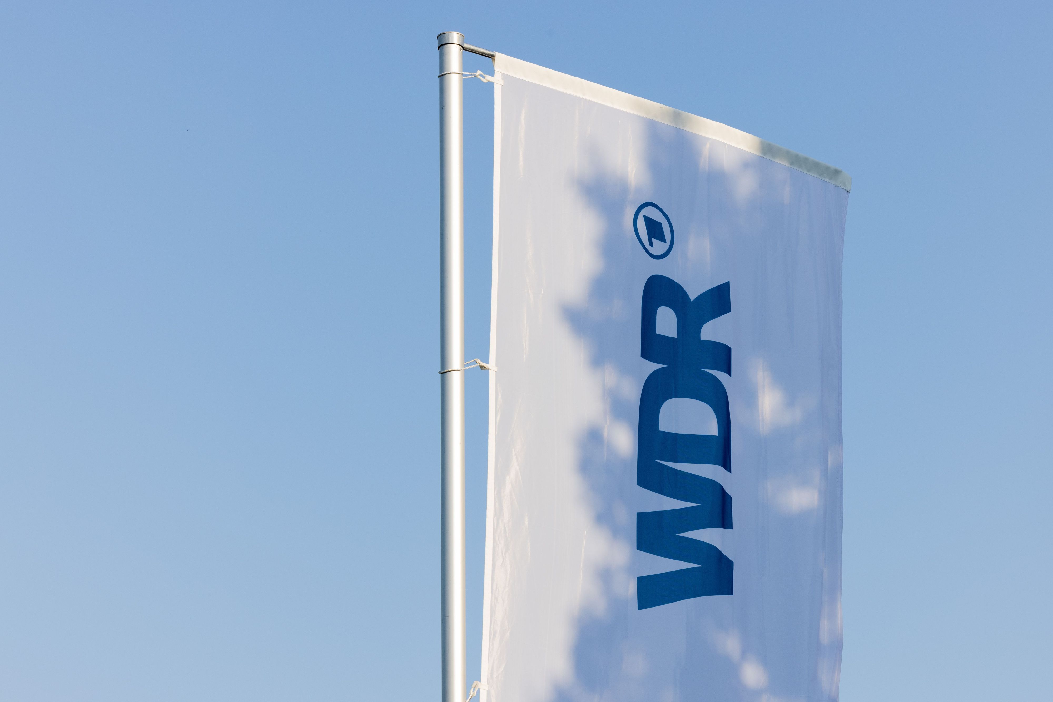Eine Fahne mit dem Logo des WDR weht auf dem Produktionsgelände in Köln. (Archivbild)