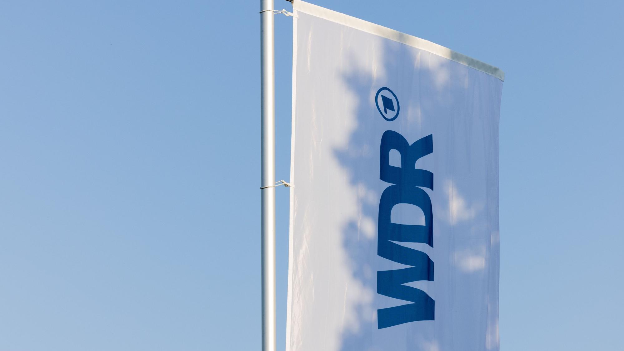 Eine Fahne mit dem Logo des WDR weht auf dem Produktionsgelände in Köln. (Archivbild)