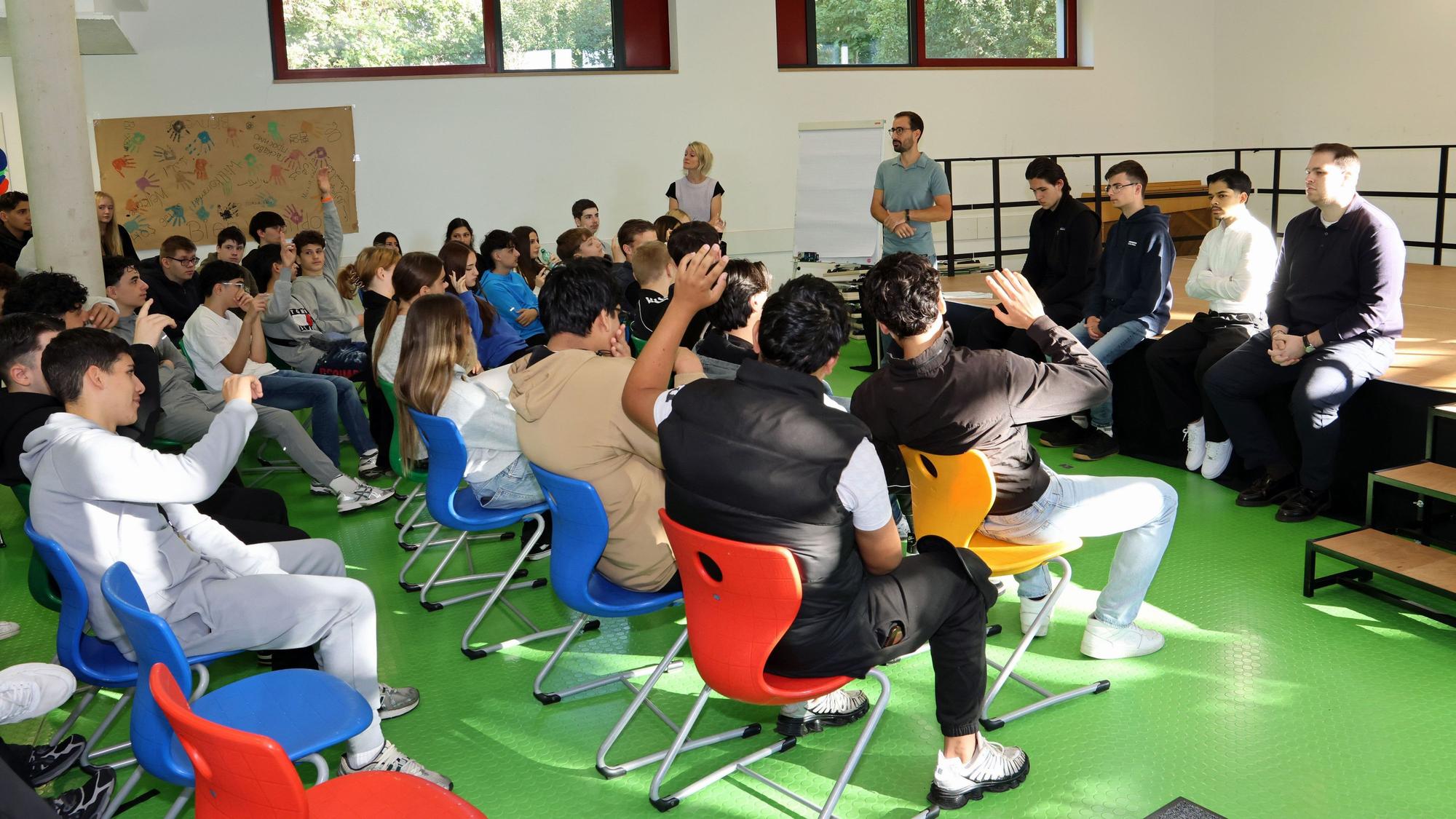 Das Bild zeigt Schüler und Auszubildende im Gespräch.
