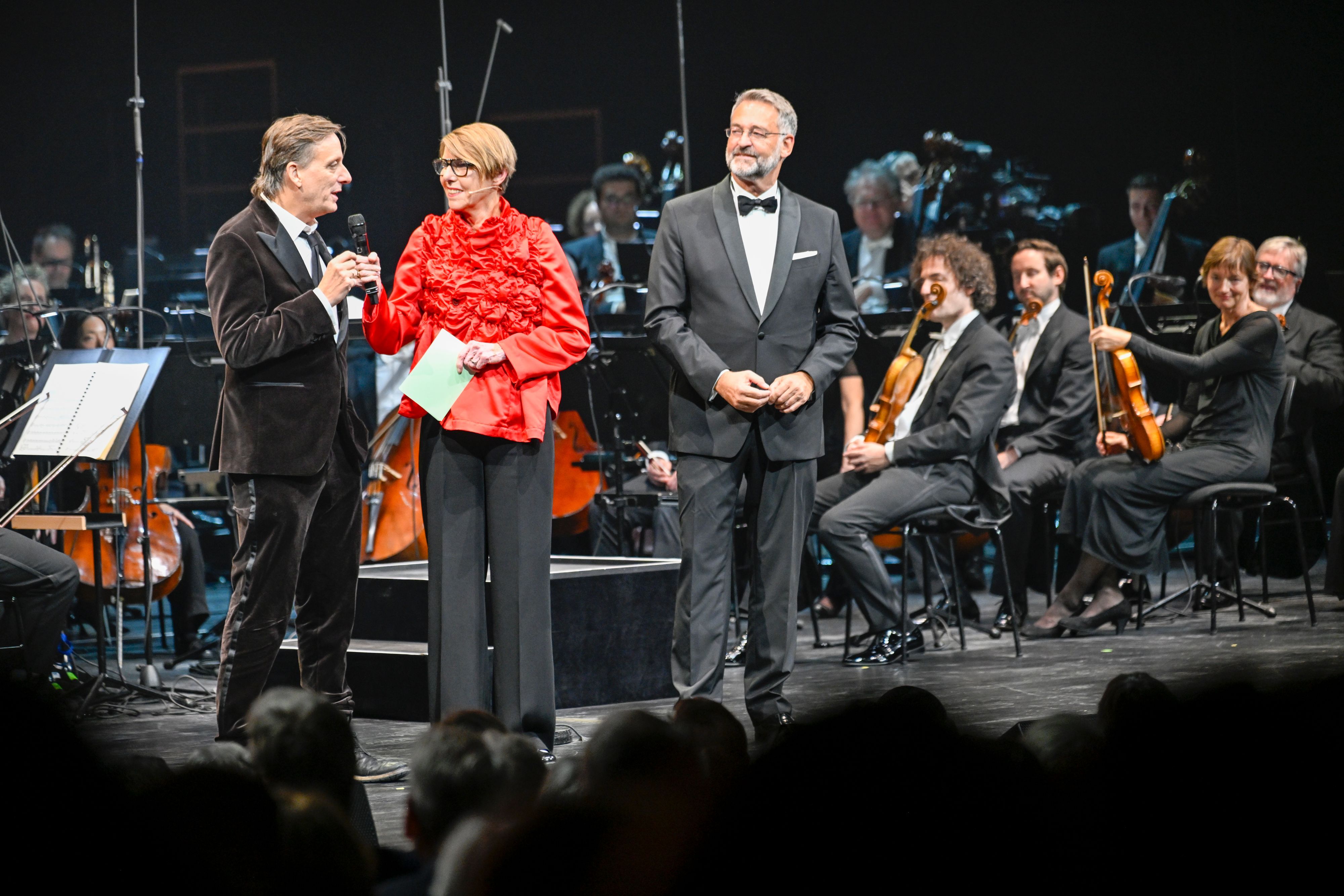 Kay Voges, Bettina Böttinger und Hein Mulders stehen auf einer Bühne.