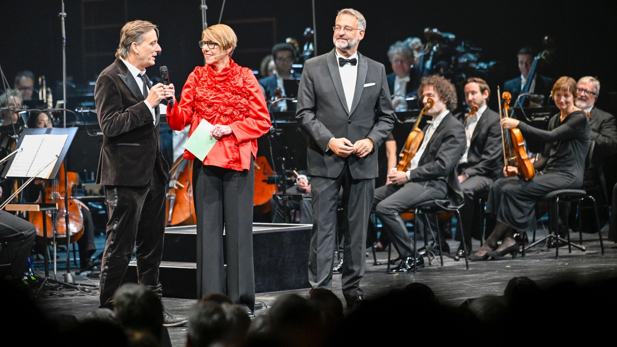 Kay Voges, Bettina Böttinger und Hein Mulders stehen auf einer Bühne.
