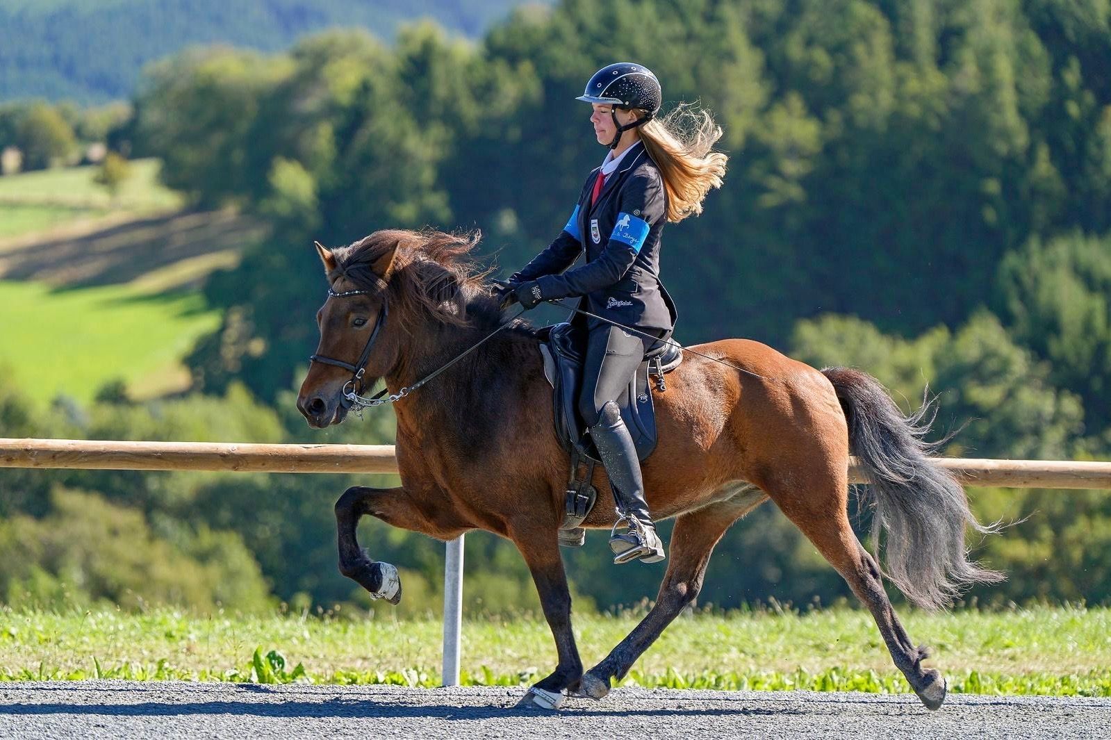 Emma Brust reitet auf einem Pferd.