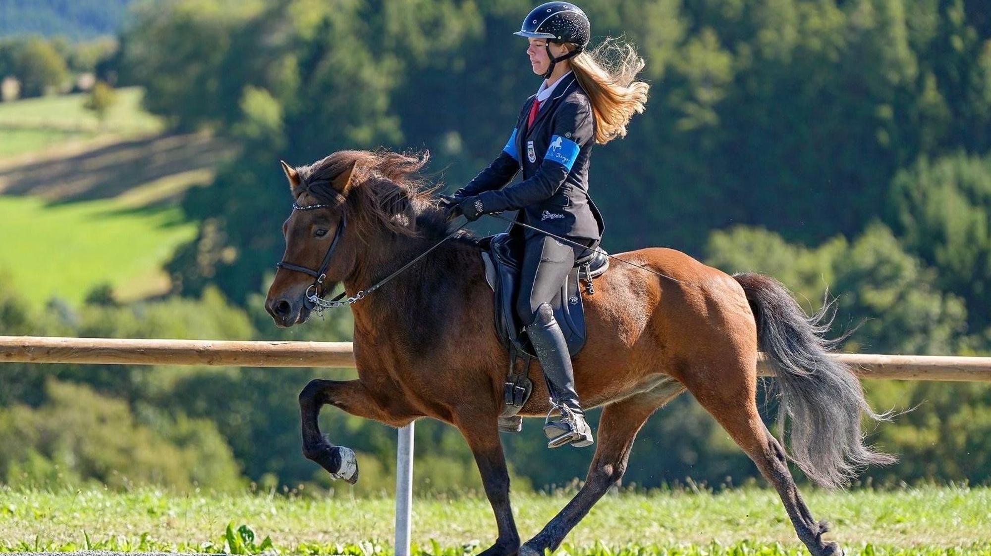 Emma Brust reitet auf einem Pferd.
