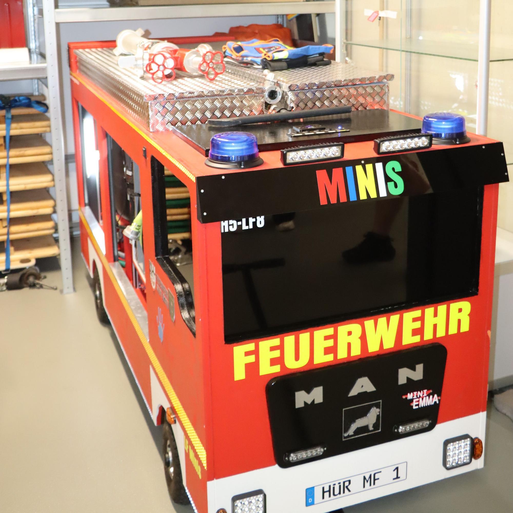 Auf dem Bild ist ein selbst gebautes Feuerwehrauto für Kinder zu sehen.