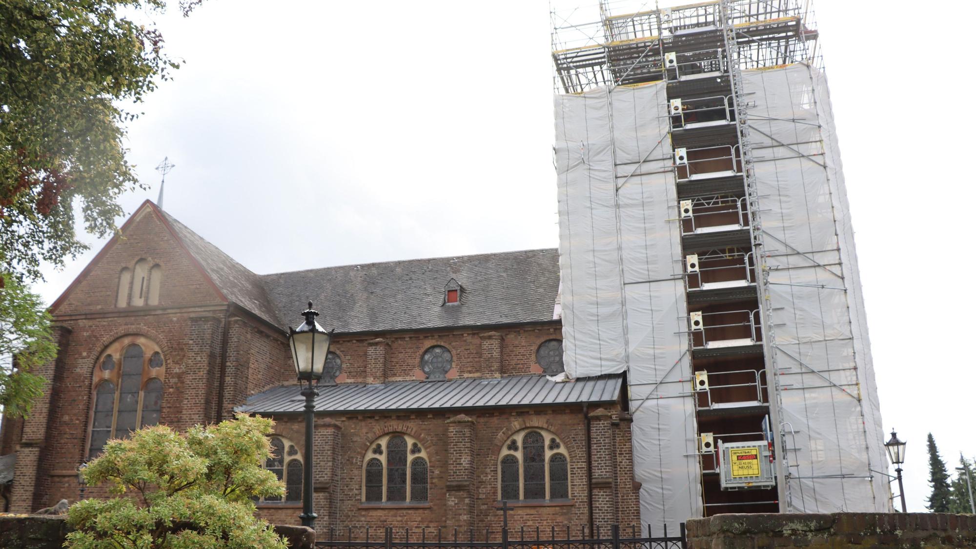 Das Bild zeigt eine Kirche, deren Turm eingerüstet ist.