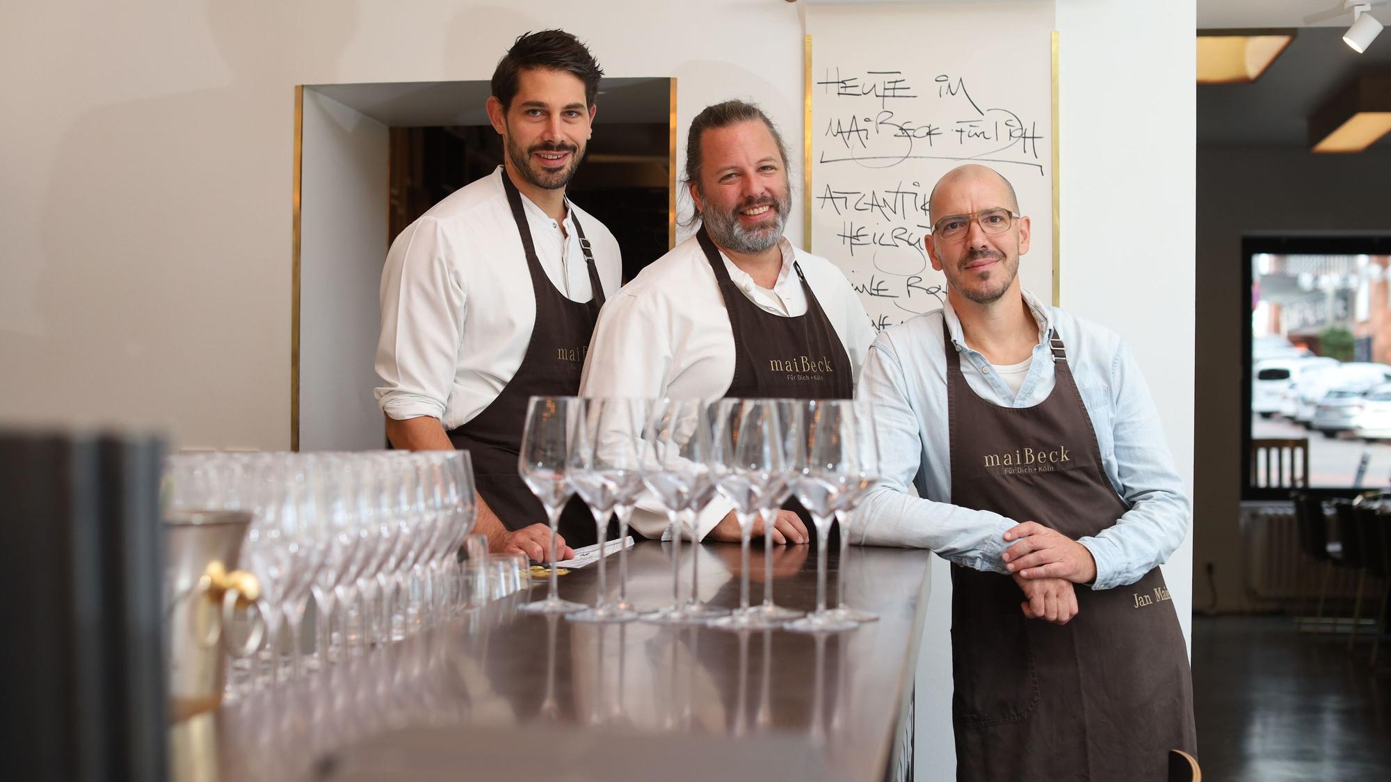 Küchenchef Johannes Adler und die Maibeck-Chefs Tobias Becker und Jan Maierstehen an der Theke des Restaurants