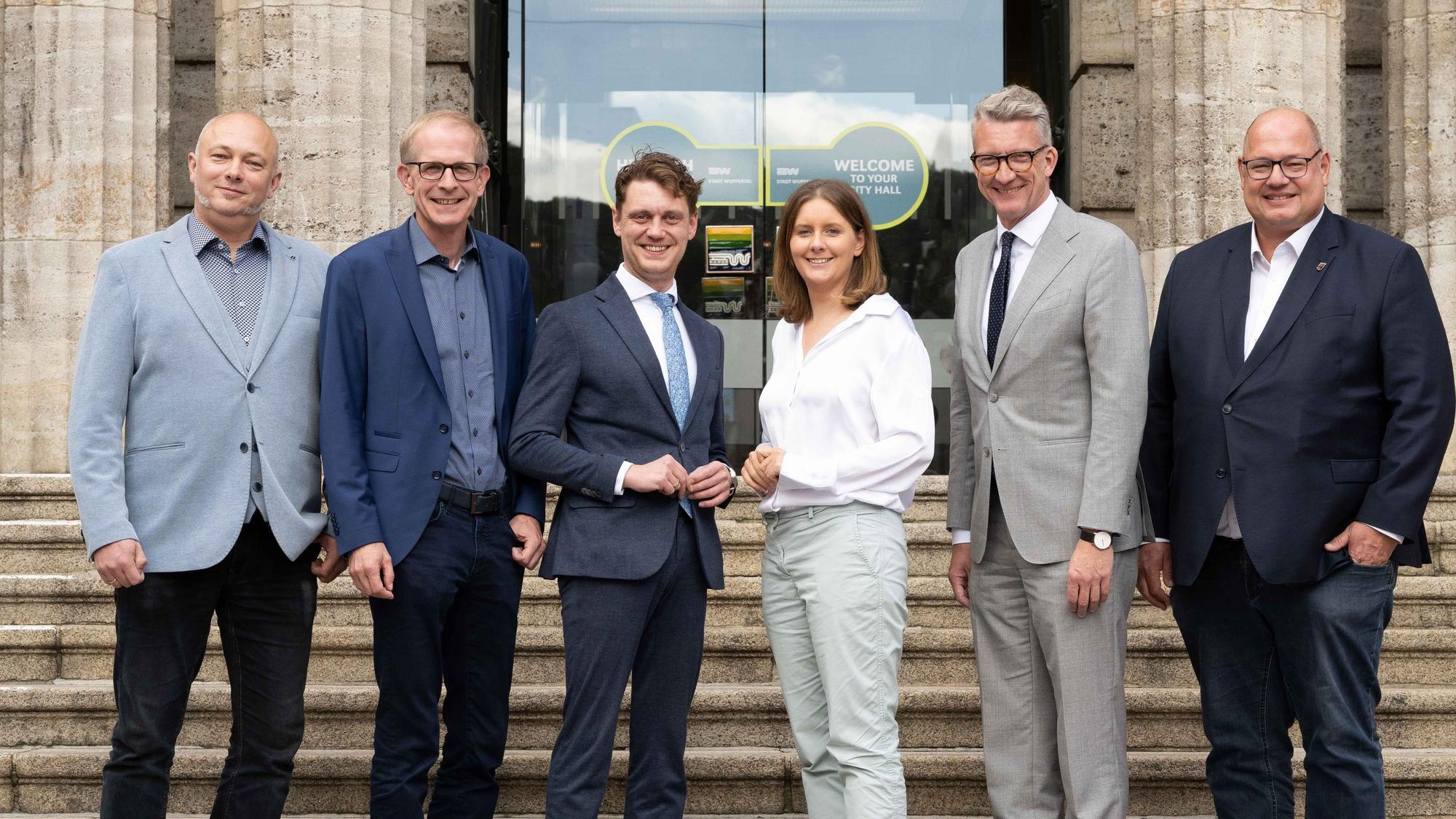 Geko-Geschäftsführer Stefan Grawe mit Langenfelds Bürgermeister Gerold Wenzens und den OBs von Solingen, Daniel Flemm, Wuppertal, Miriam Scherff, Sven Wolf aus Remscheid und Stefan Hebbel aus Leverkusen vor dem Wuppertaler Rathaus