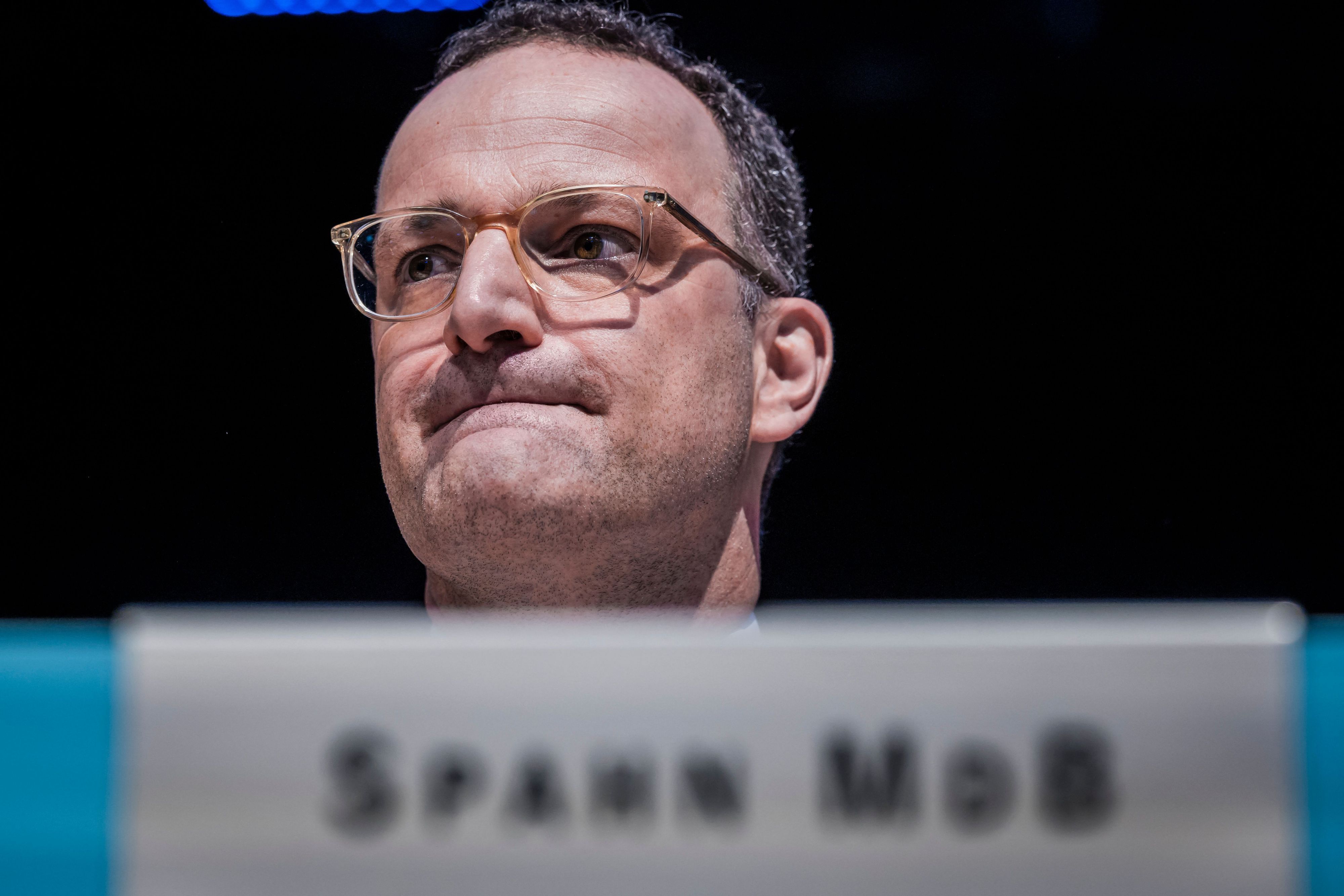 Jens Spahn sitzt im Bundestag und zieht die Lippen ein.