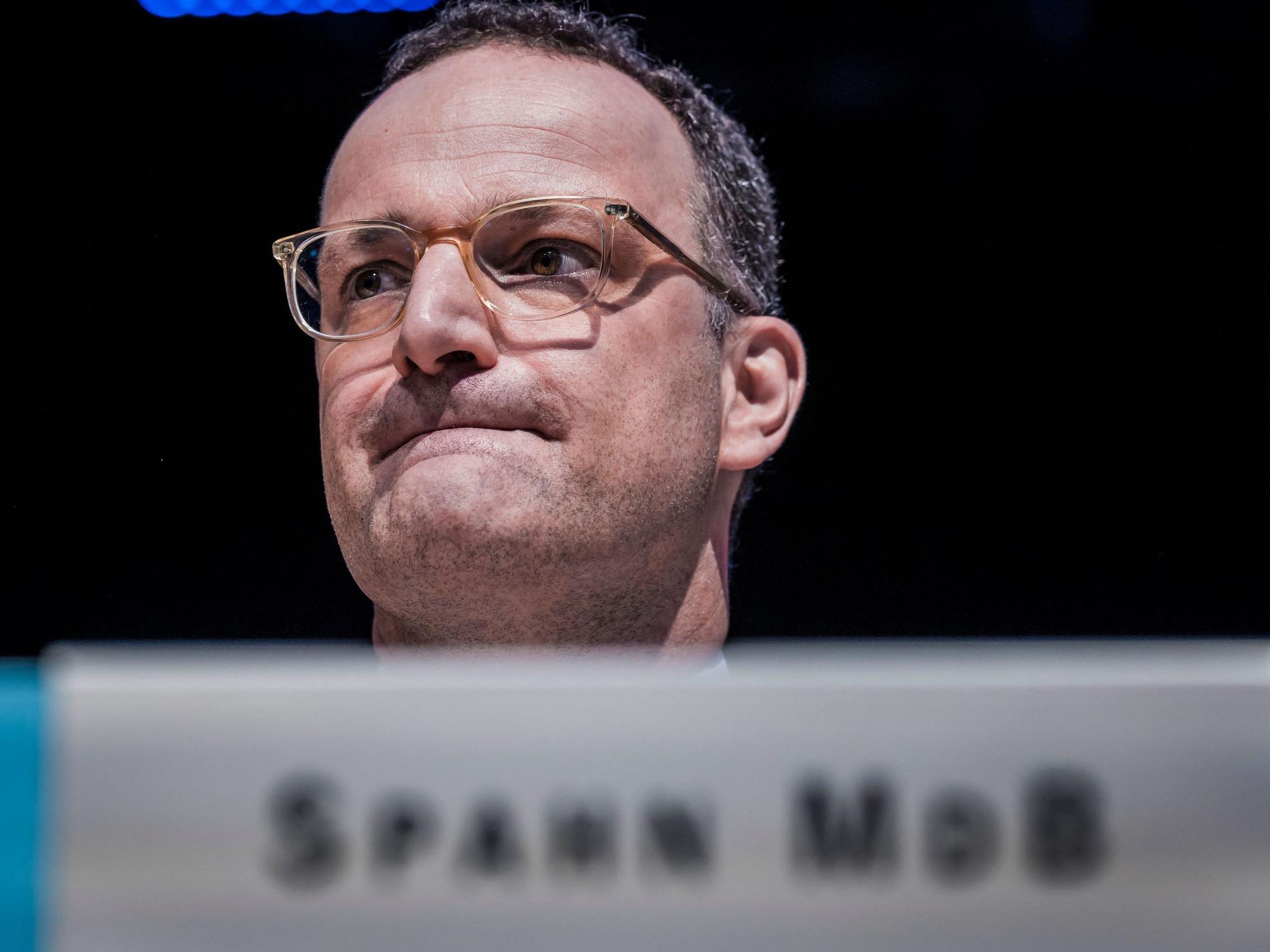 Jens Spahn sitzt im Bundestag und zieht die Lippen ein.