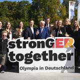 Bundespräsident Frank-Walter Steinmeier (Mitte ) mit Sportlern und DOSB-Präsident Thomas Weikert (Mitte hinten) am Rande des Olympia-Entscheids in Baden-Baden.