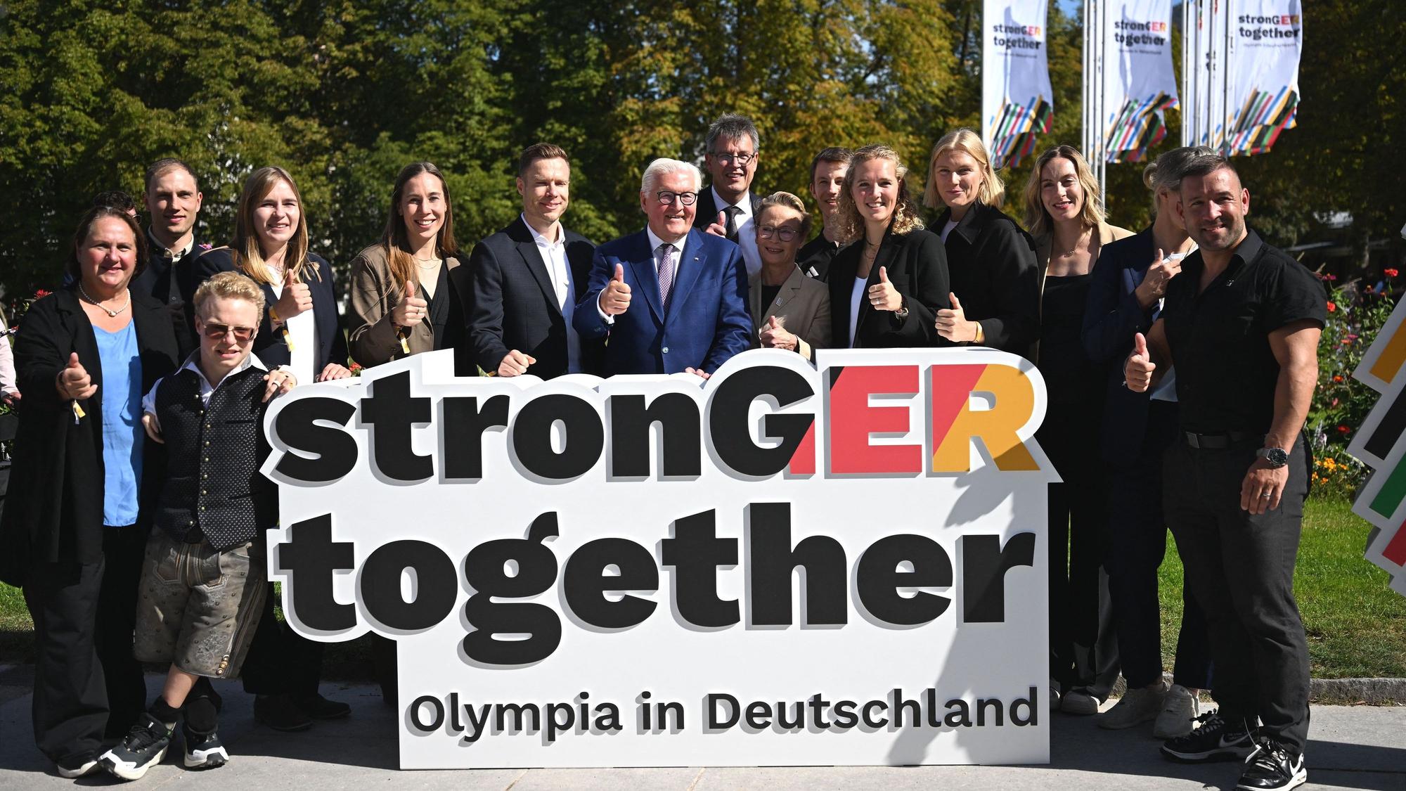 Bundespräsident Frank-Walter Steinmeier (Mitte ) mit Sportlern und DOSB-Präsident Thomas Weikert (Mitte hinten) am Rande des Olympia-Entscheids in Baden-Baden.