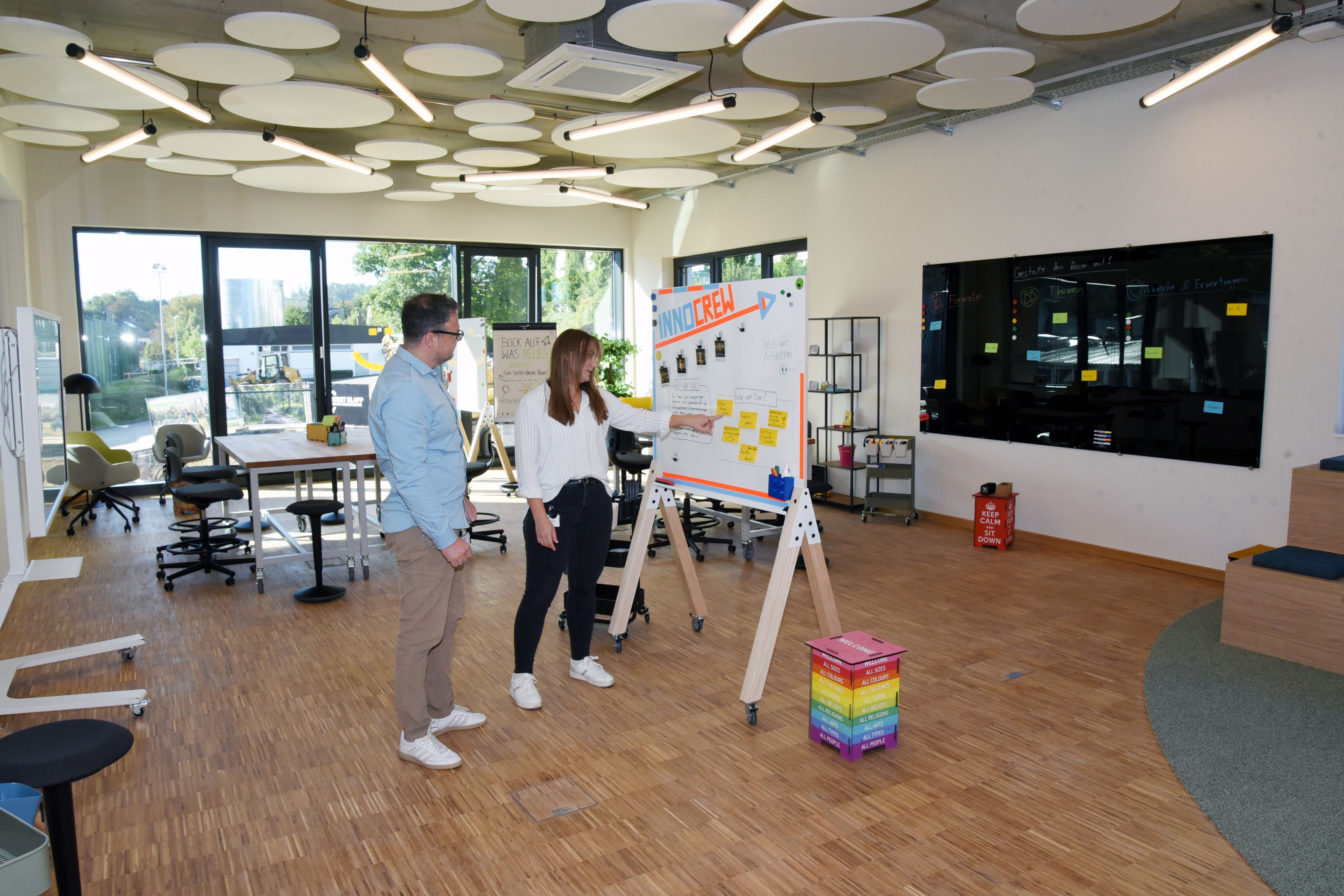 Eine Frau und ein Mann an einem Flipchart.