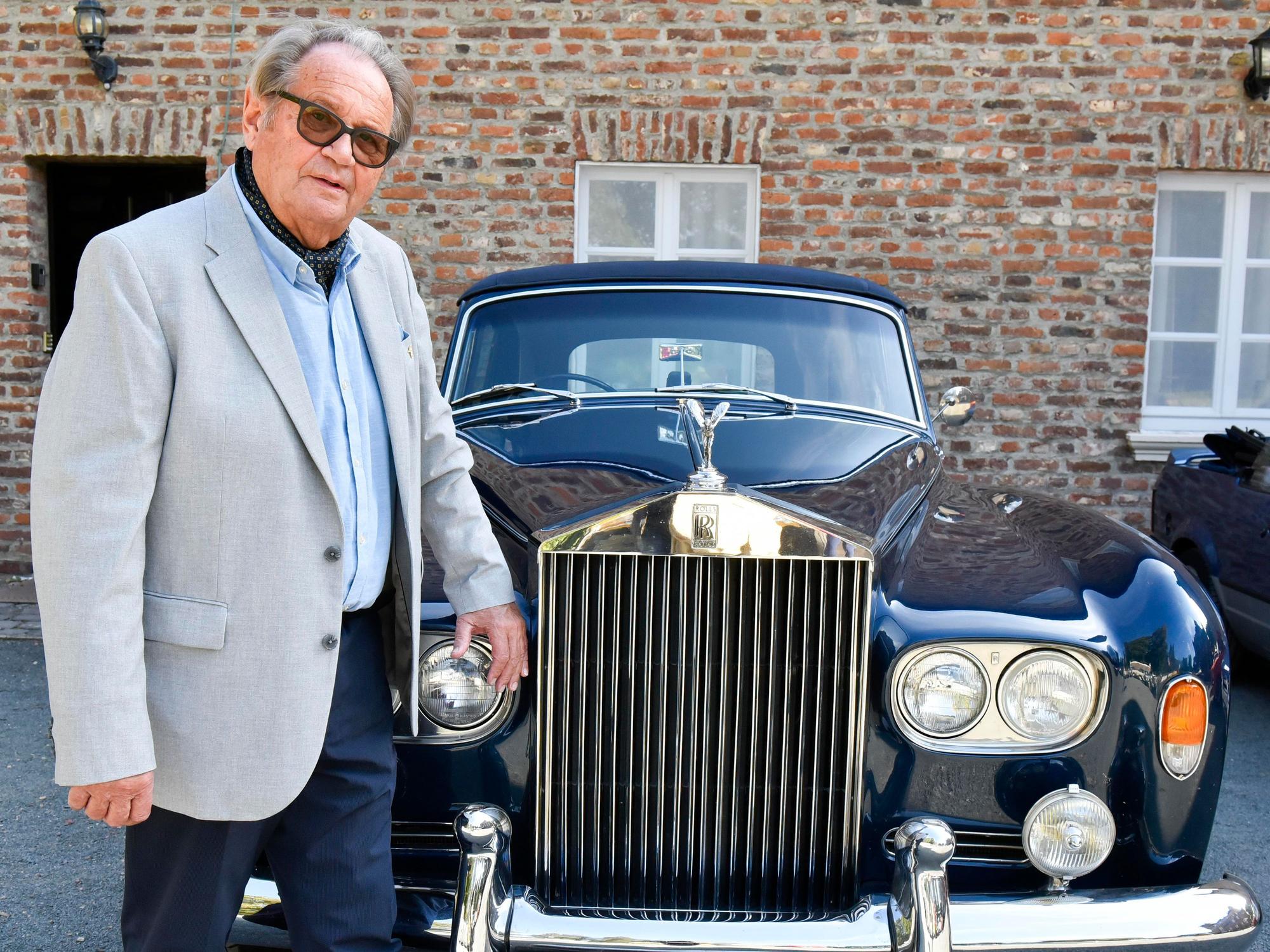 Das Bild zeigt einen Mann mit seinem blauen Rolls Royce Kombi Silver Shadow III.