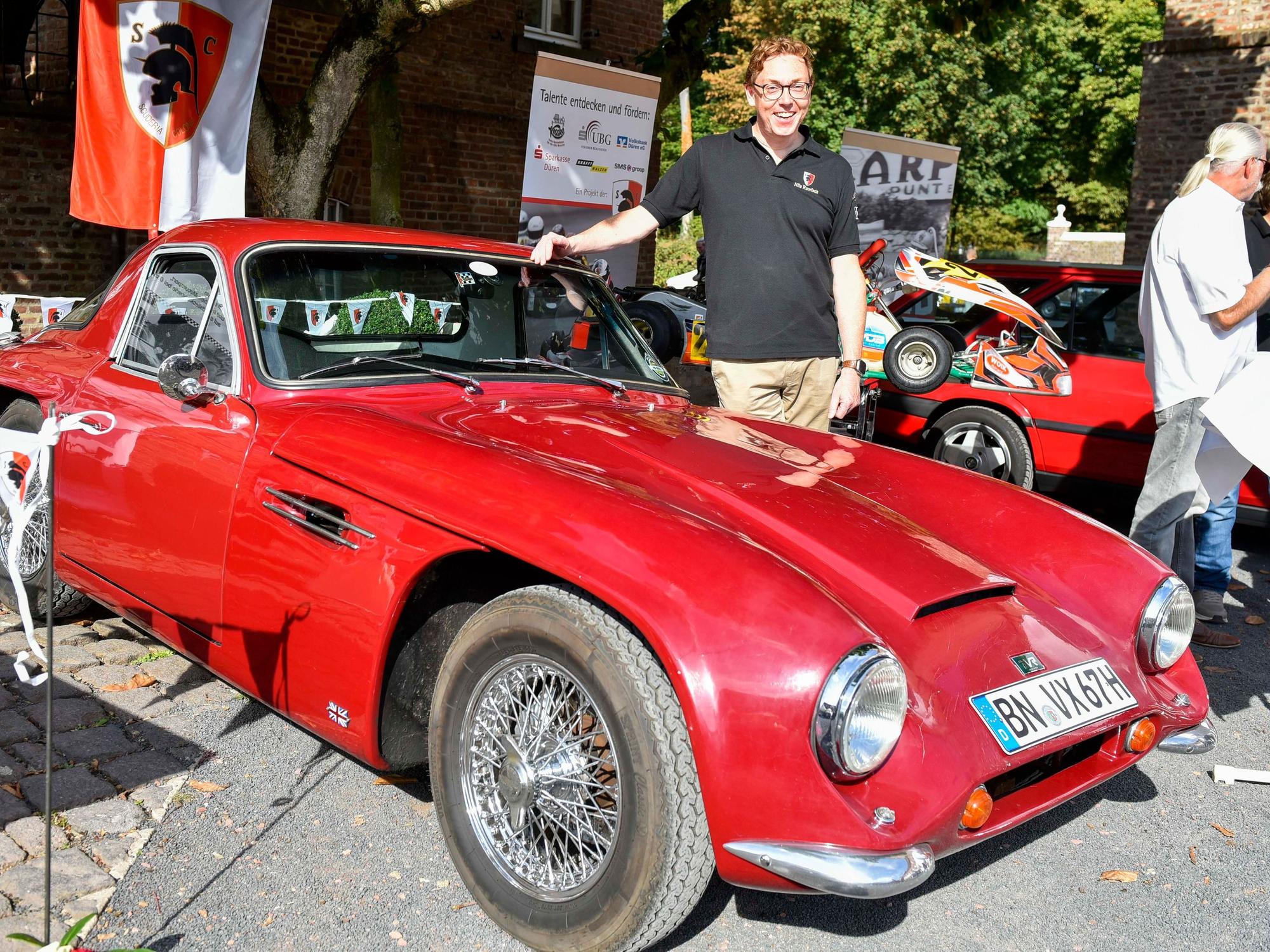 Das Bild zeigt einen Mann mit seinem roten TVR, Baujahr 1967, der einmal Roger Moore gehört haben soll.