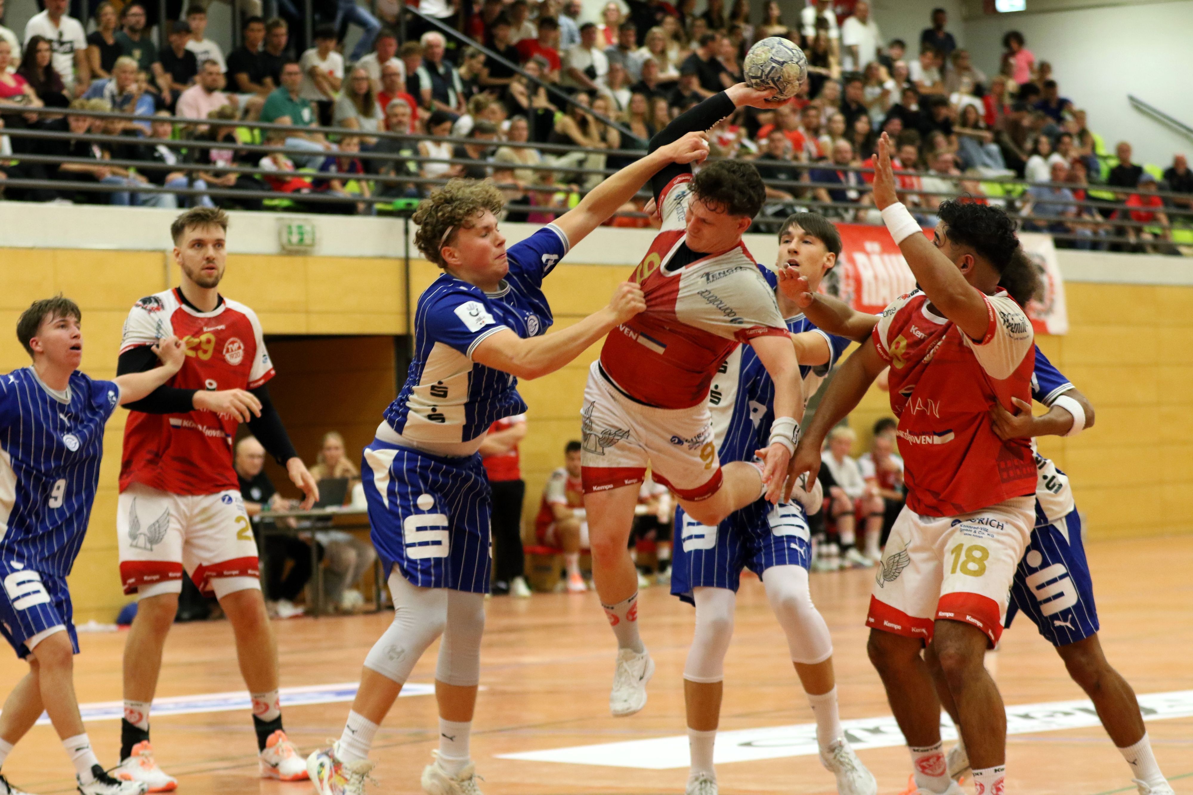 Marius Schmitz wird am Wurf von einem Gegenspieler gehindert, der Schmitz am Trikot reißt und an den Arm fasst.