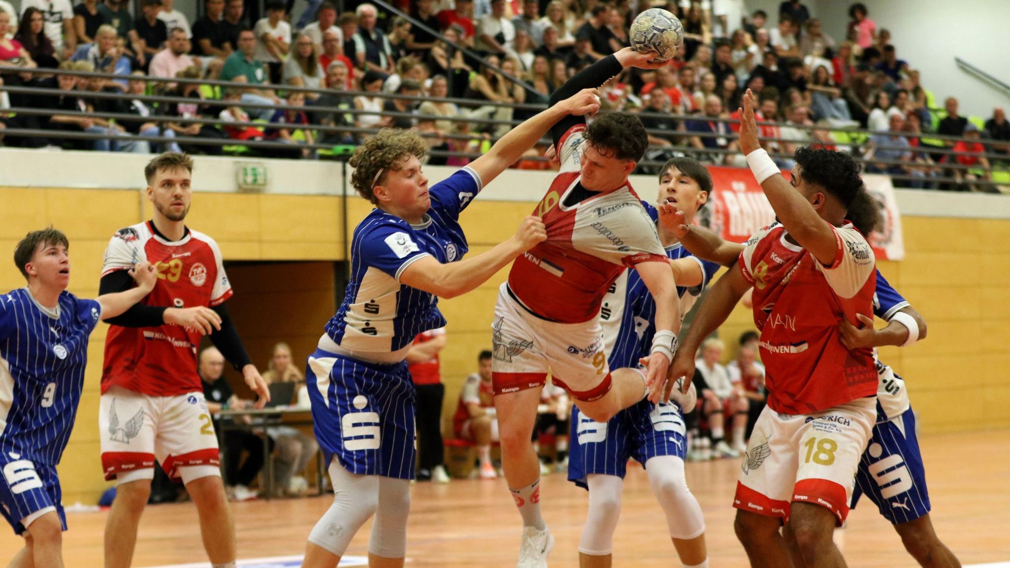 Marius Schmitz wird am Wurf von einem Gegenspieler gehindert, der Schmitz am Trikot reißt und an den Arm fasst.