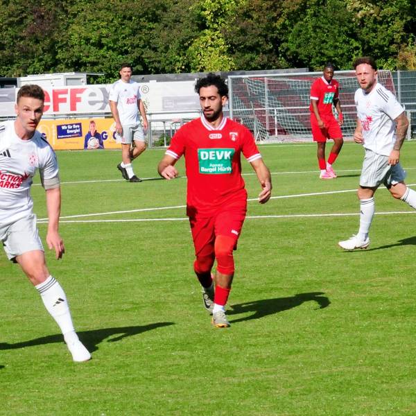 Thomas Leßenich führt den Ball. Ein Spieler von Hürth kommt von der Seite angelaufen.