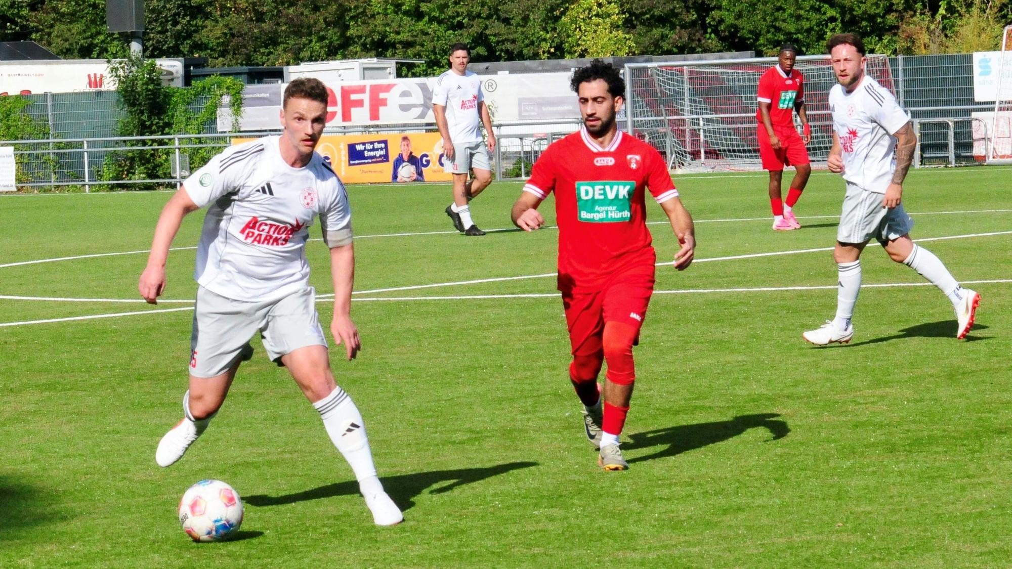 Thomas Leßenich führt den Ball. Ein Spieler von Hürth kommt von der Seite angelaufen.