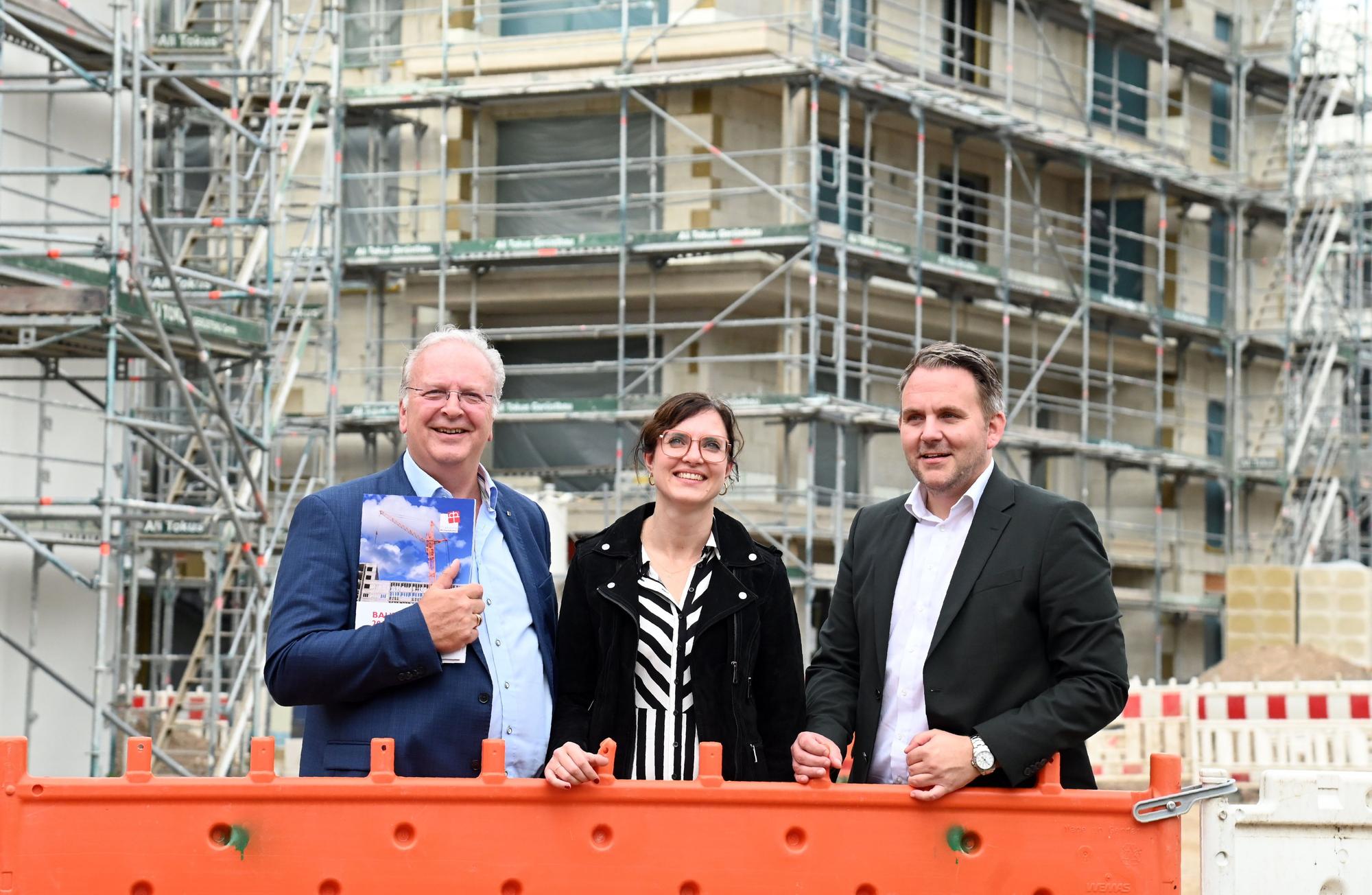 Uwe Ufer, Kirsten Neveling und Christian Potthoff stehen im Gruppenbild vor dem Rohbau.