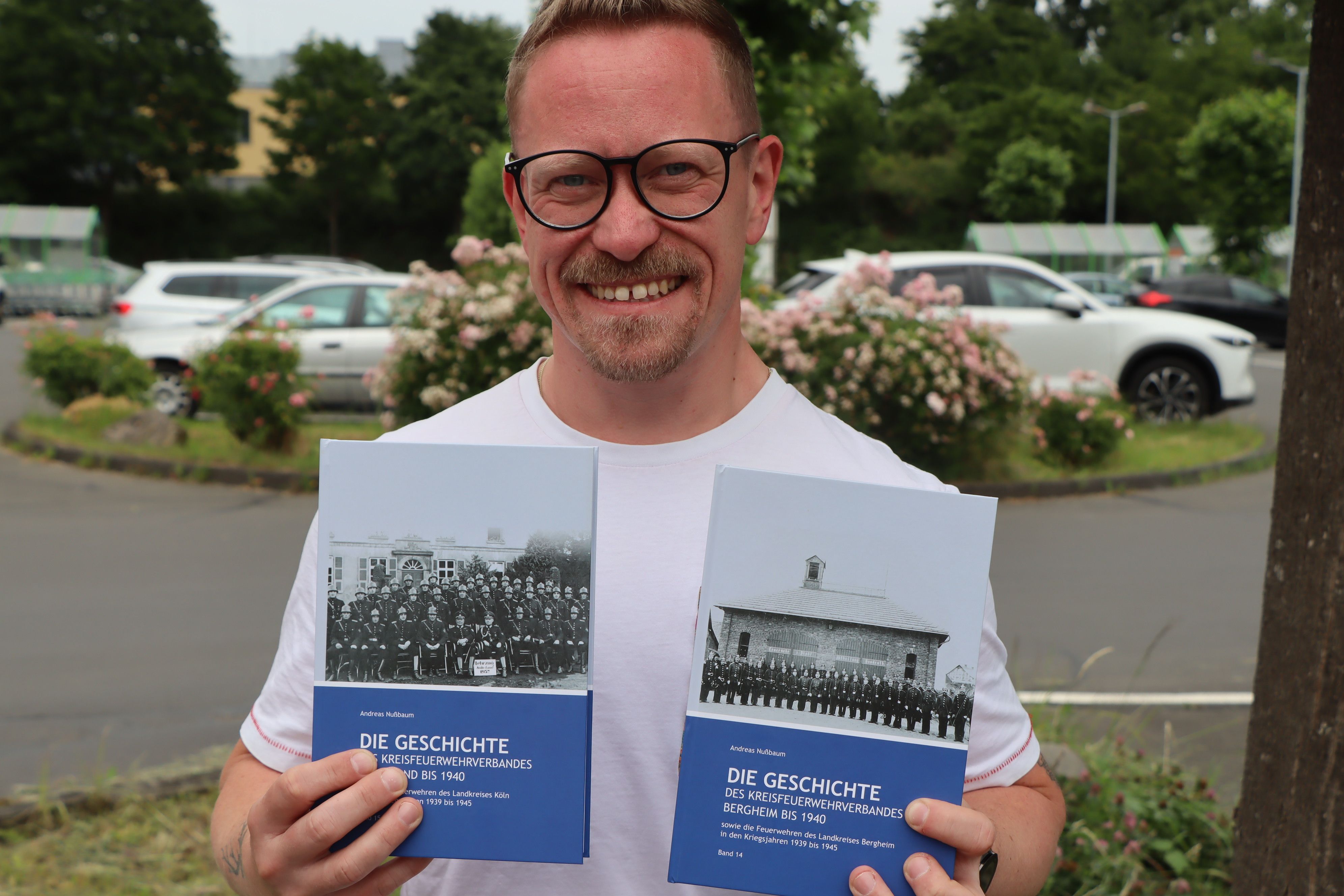 Das Foto zeigt den Feuerwehrmann und Autor mit seinen neuen Büchern.
