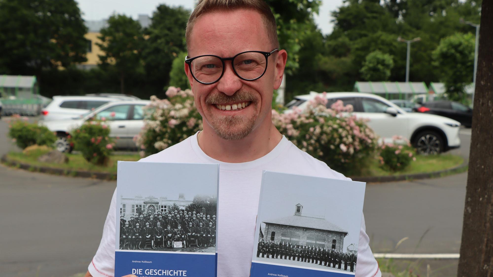 Das Foto zeigt den Feuerwehrmann und Autor mit seinen neuen Büchern.