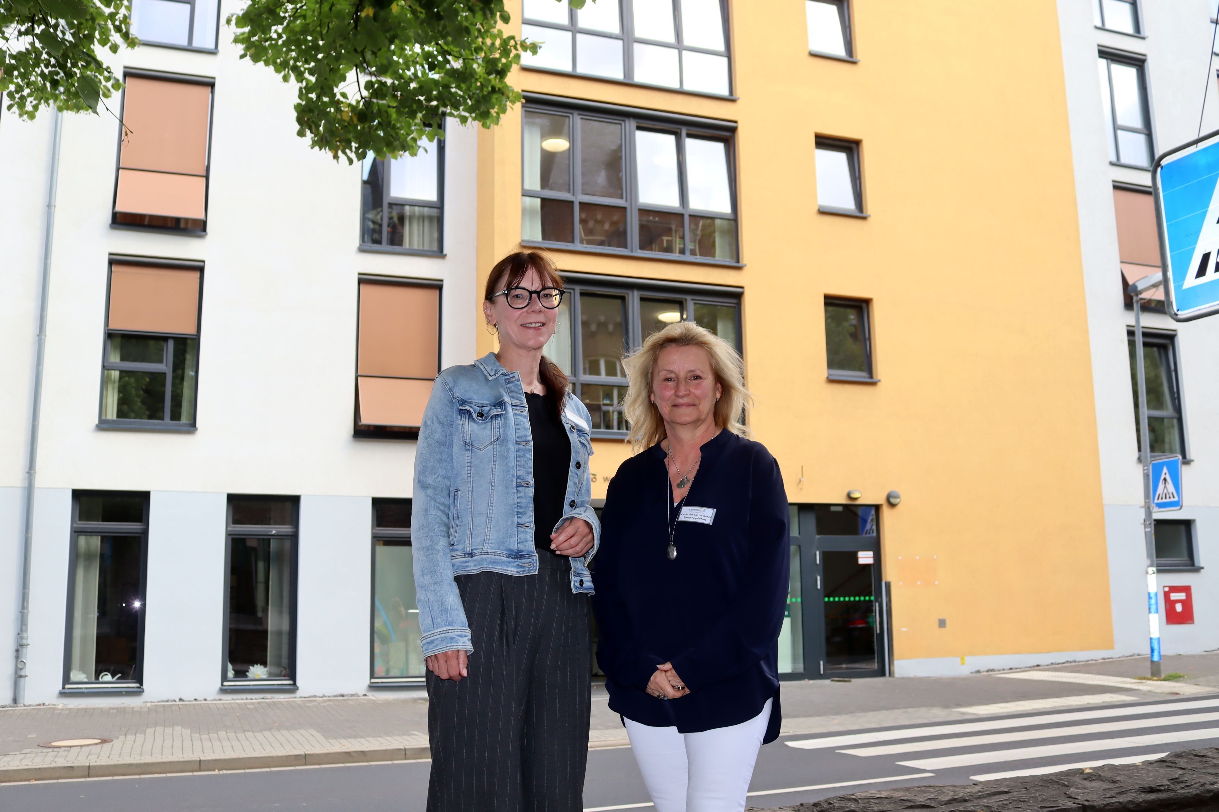 Die beiden Genannten stehen an der Straße vor einem mehrstöckigen Gebäude in Bad Münstereifel.