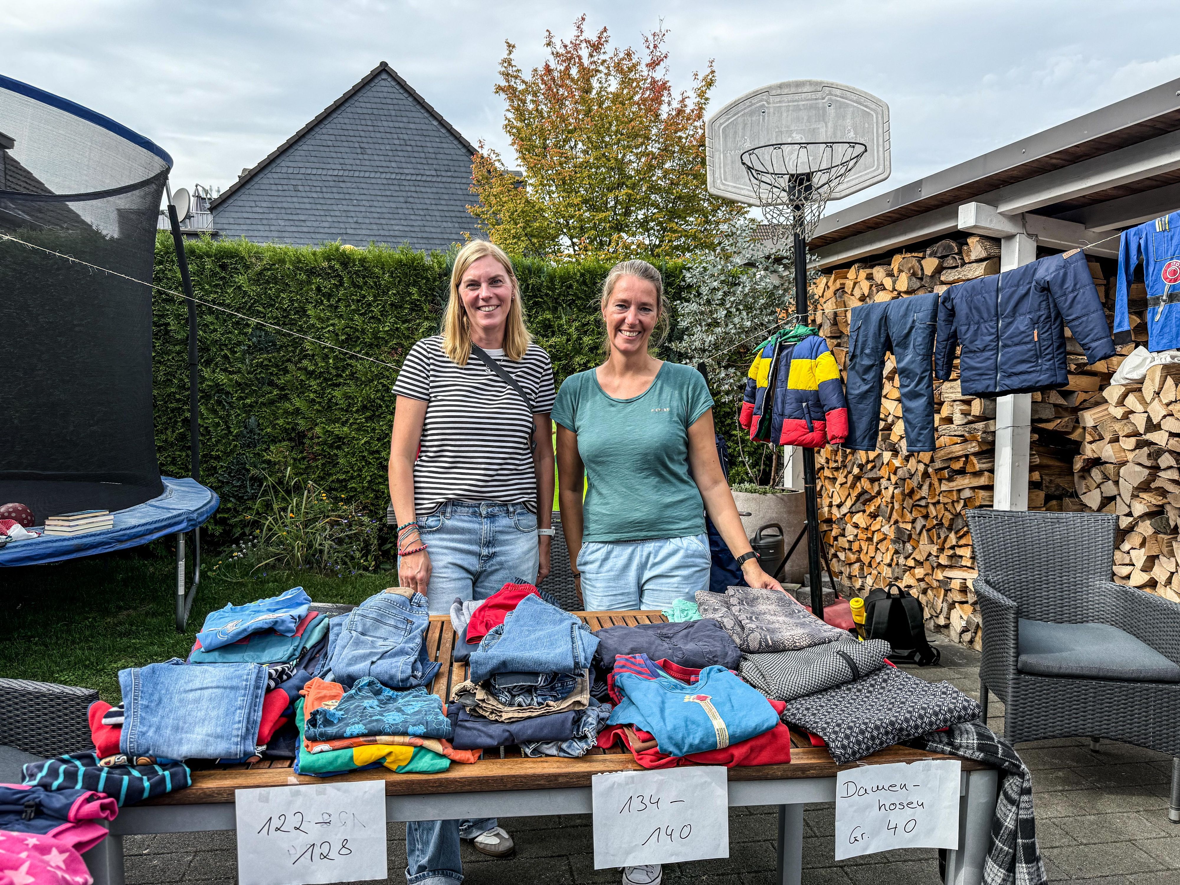Lena und Maria verkaufen fleißig die alten Klamotten ihrer Kinder.