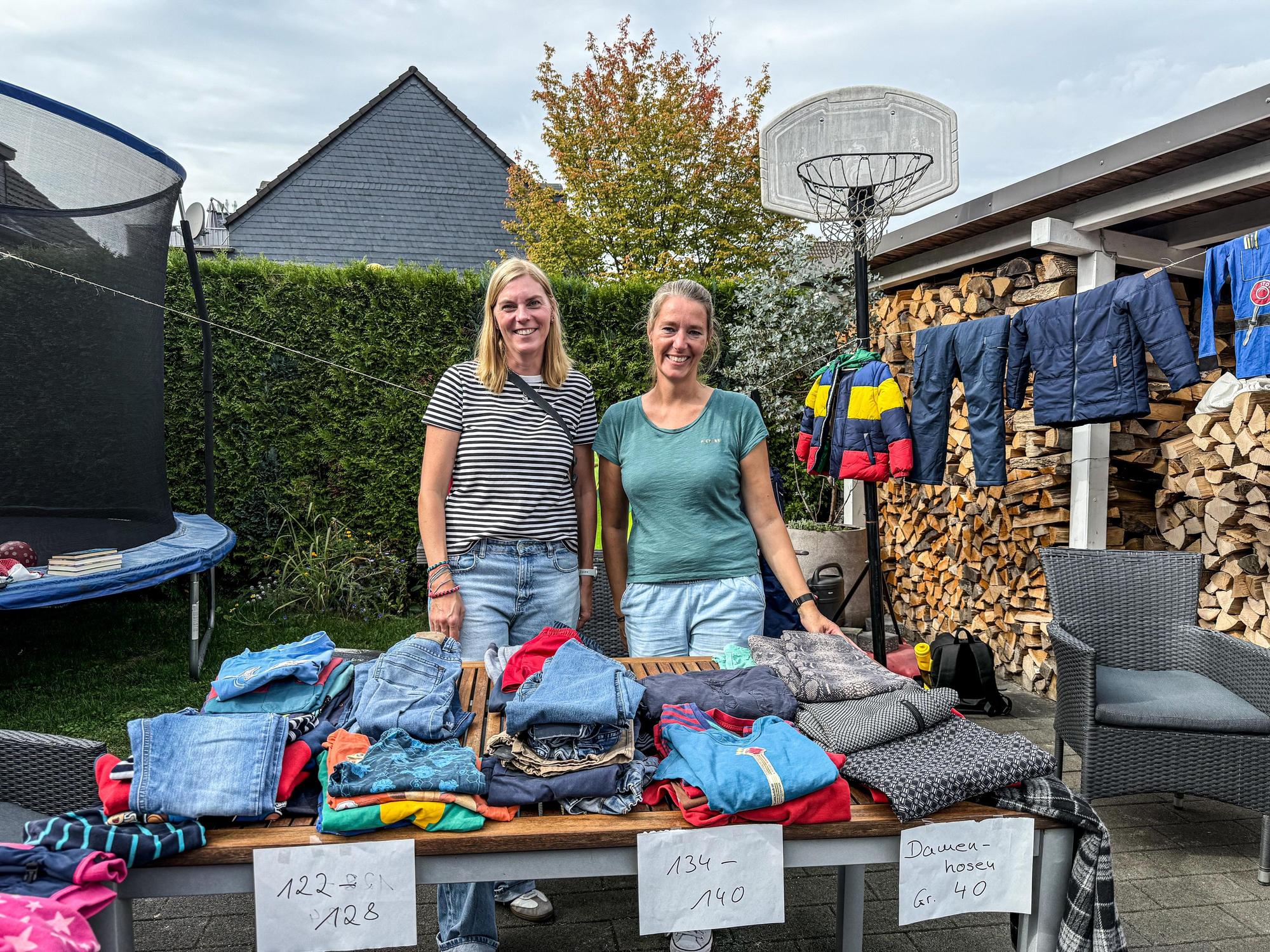 Lena und Maria verkaufen fleißig die alten Klamotten ihrer Kinder.