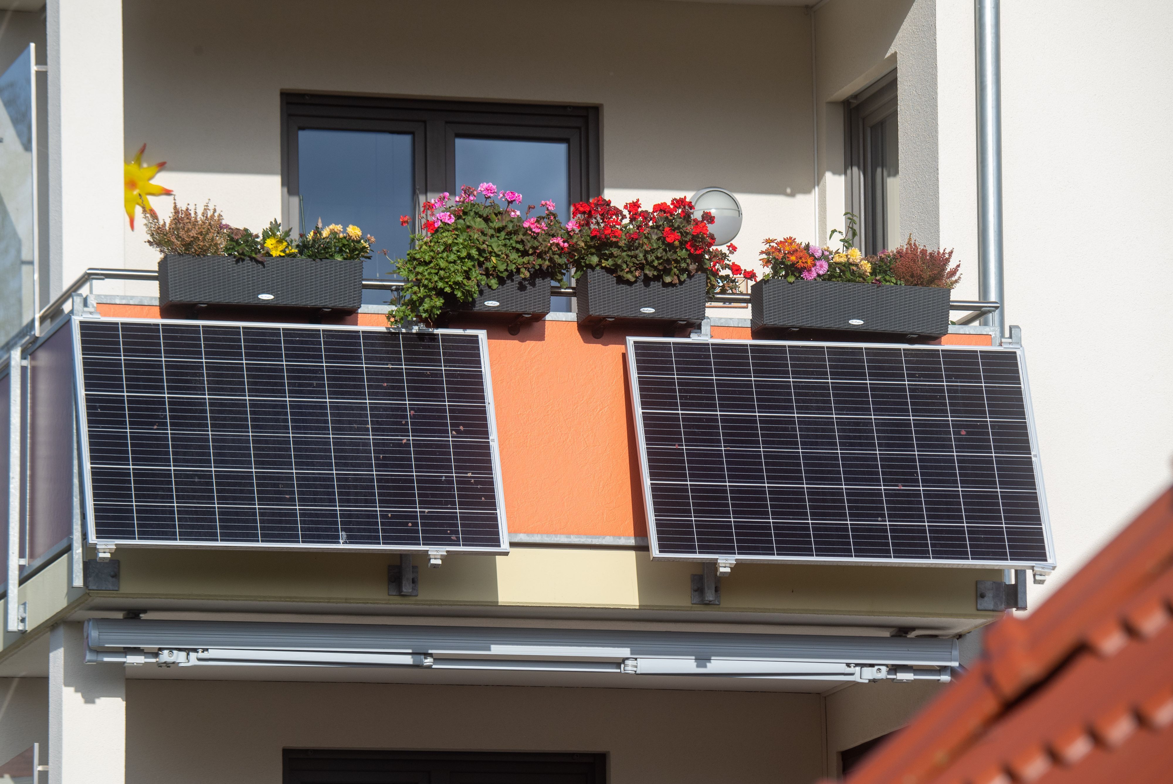 Solarmodule für ein sogenanntes Balkonkraftwerk hängen an einem Balkon.