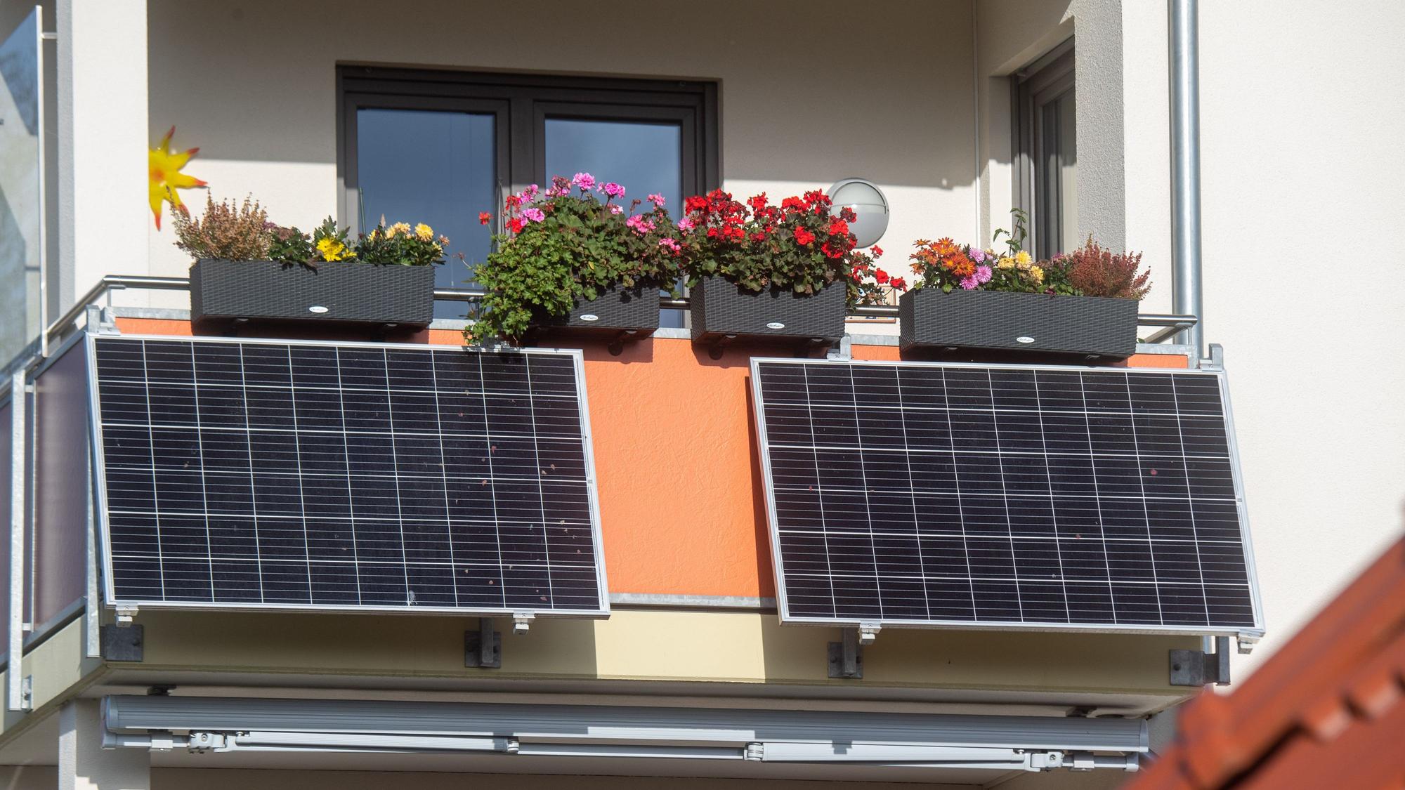 Solarmodule für ein sogenanntes Balkonkraftwerk hängen an einem Balkon.